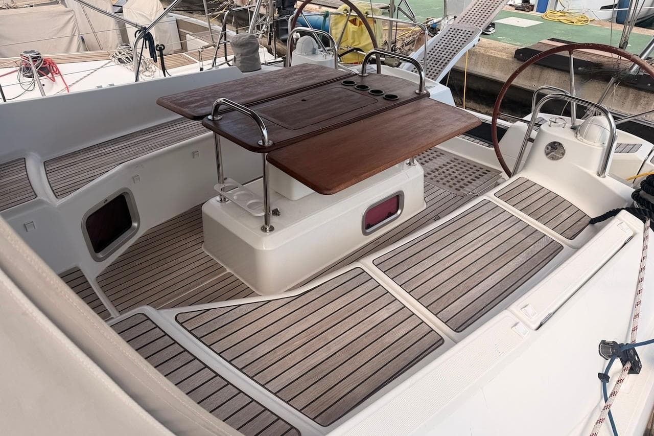 Cockpit of 2008 Jeanneau Sun Odyssey 45 DS sailboat with wooden table and dual steering wheels.