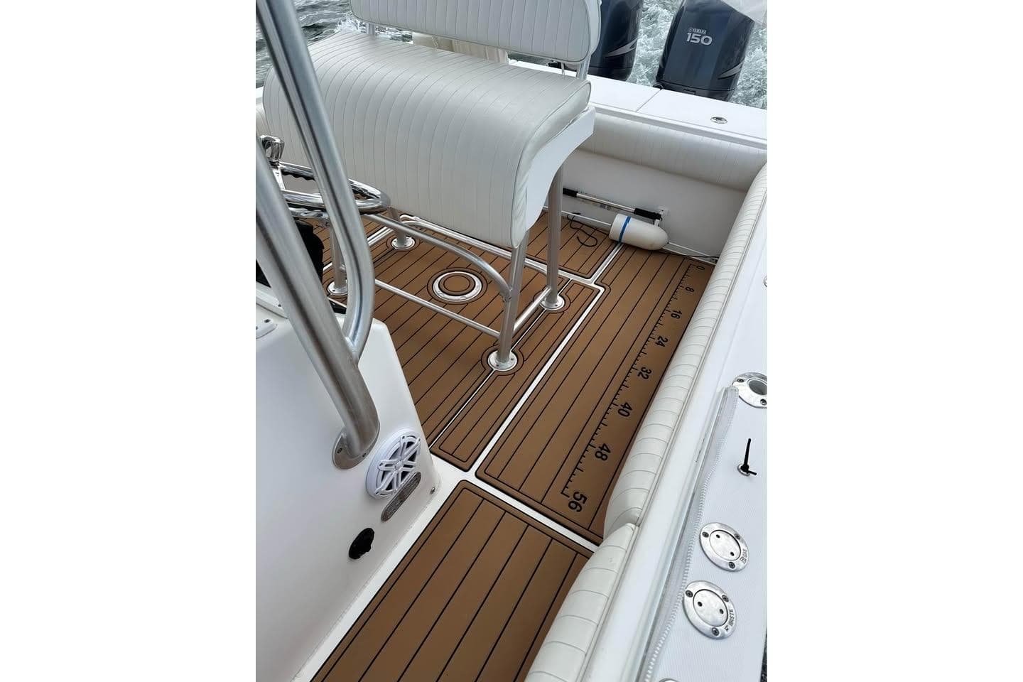 2006 Regulator 24 Forward Seating boat interior with teak flooring and white seating.