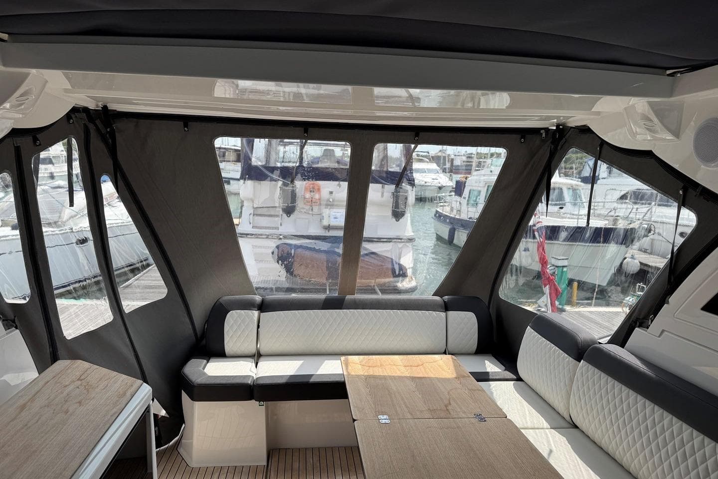 Interior of 2023 Bavaria SR41 yacht with elegant seating and marina view.