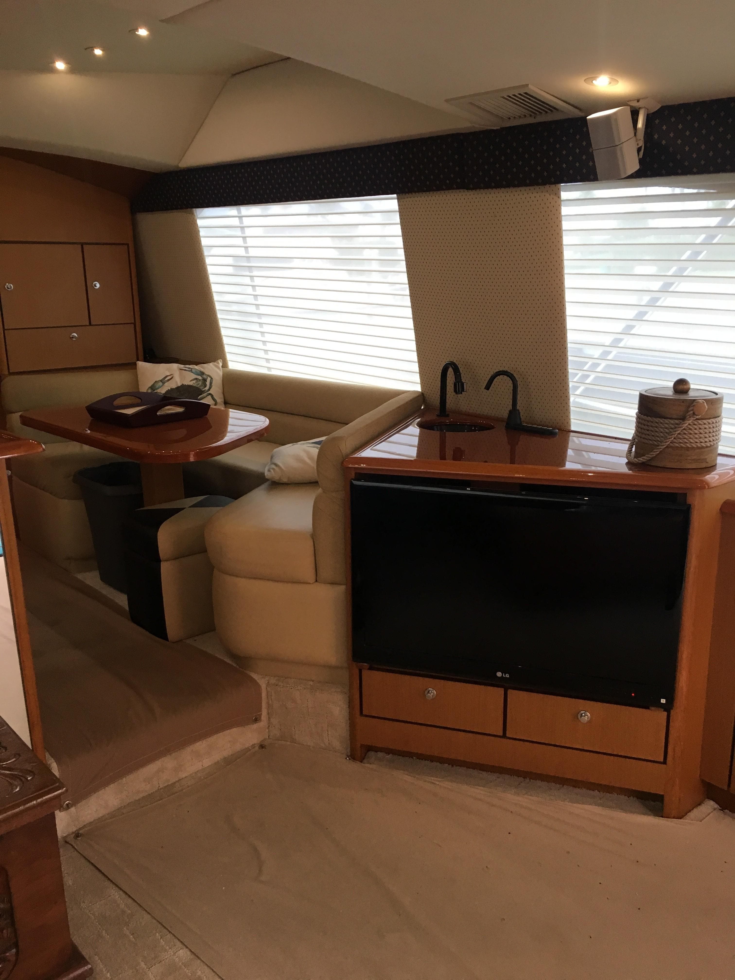 Interior of 2001 Ocean Yachts 56 Super Sport with dining area and entertainment center.
