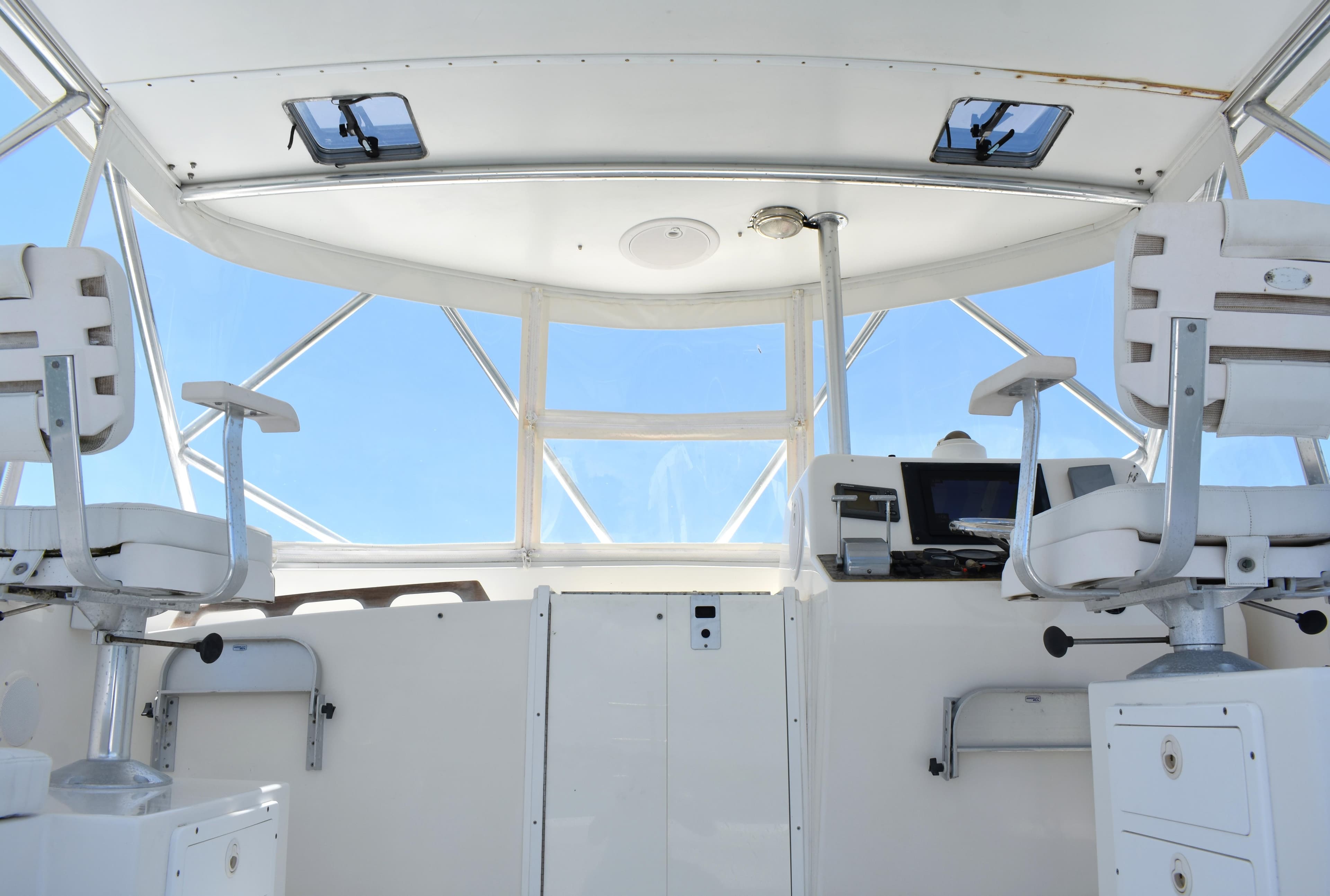 Interior view of 2004 Judge 34 Express boat cockpit with white seating and navigation equipment.