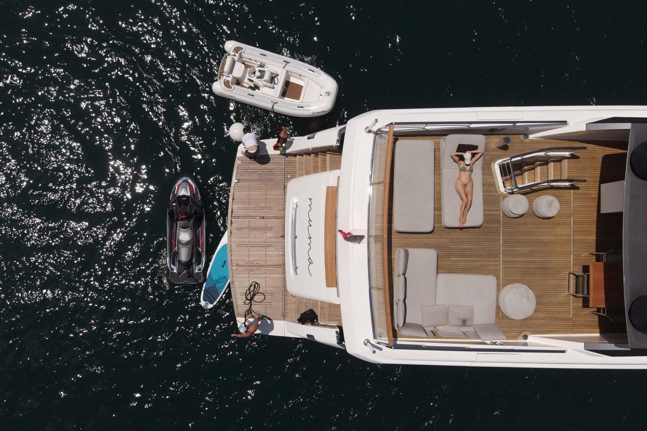 Aerial view of 2016 SL96 yacht with sunbathing area and watercrafts on a sunny day.