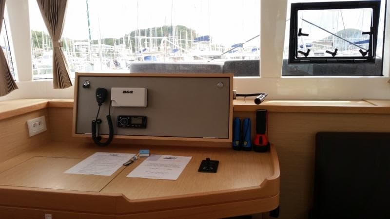 Navigation station inside a 2017 Lagoon 450S catamaran, featuring communication equipment and documents.