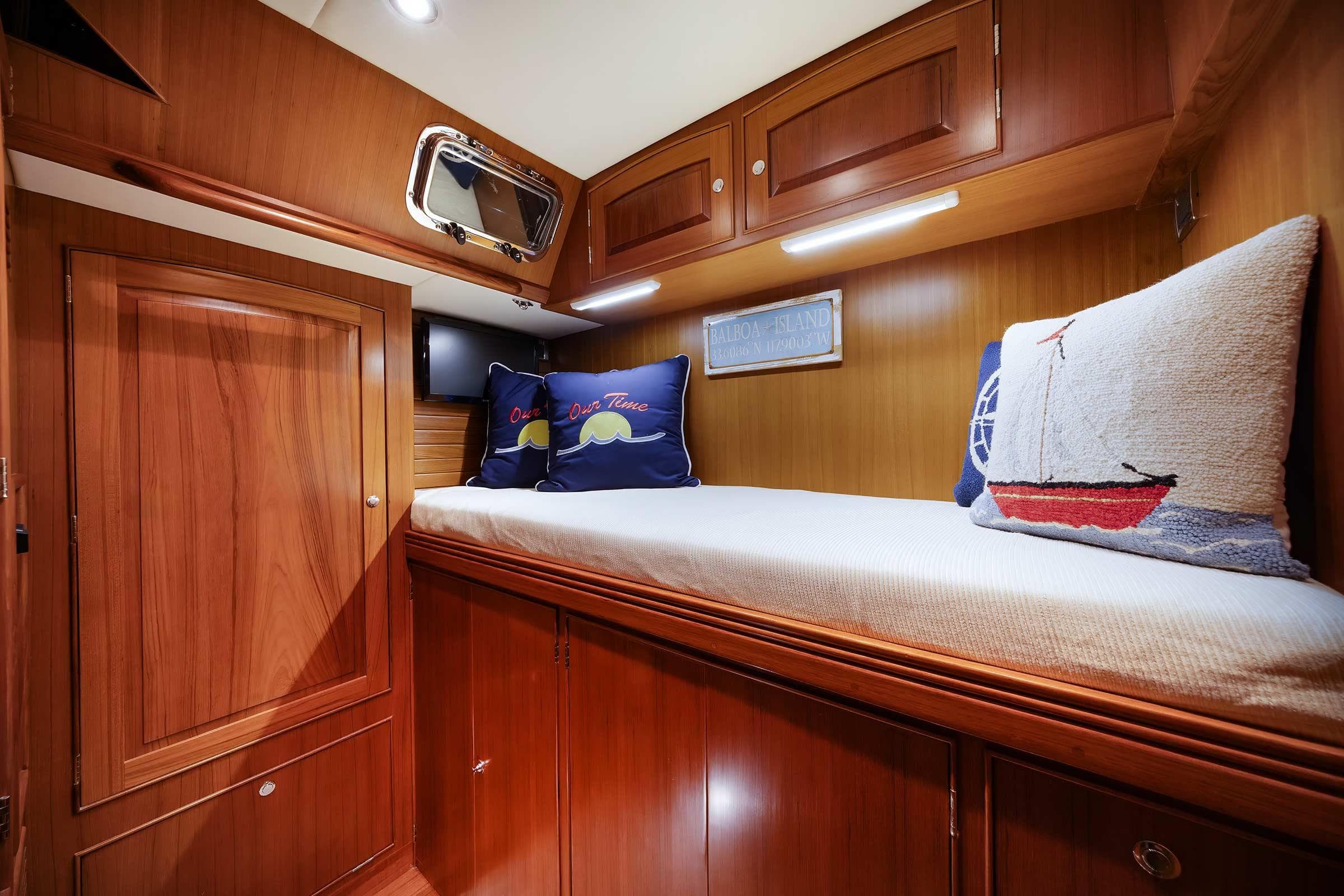 Luxurious wooden cabin interior of 2014 Hylas 63 yacht with cozy bedding and nautical decor.