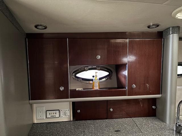2005 Formula 400 SS yacht interior with wooden cabinets and porthole window.