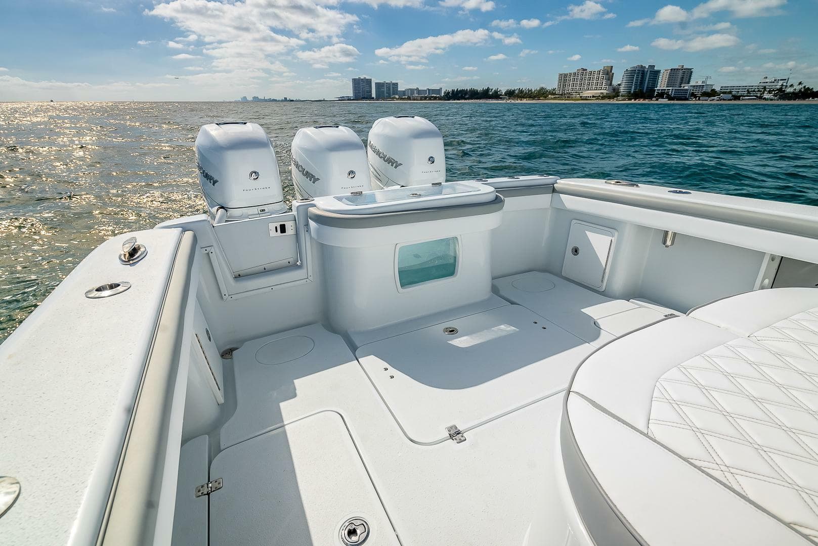2023 Yellowfin 36 Offshore boat on water, featuring spacious deck and triple outboard engines.
