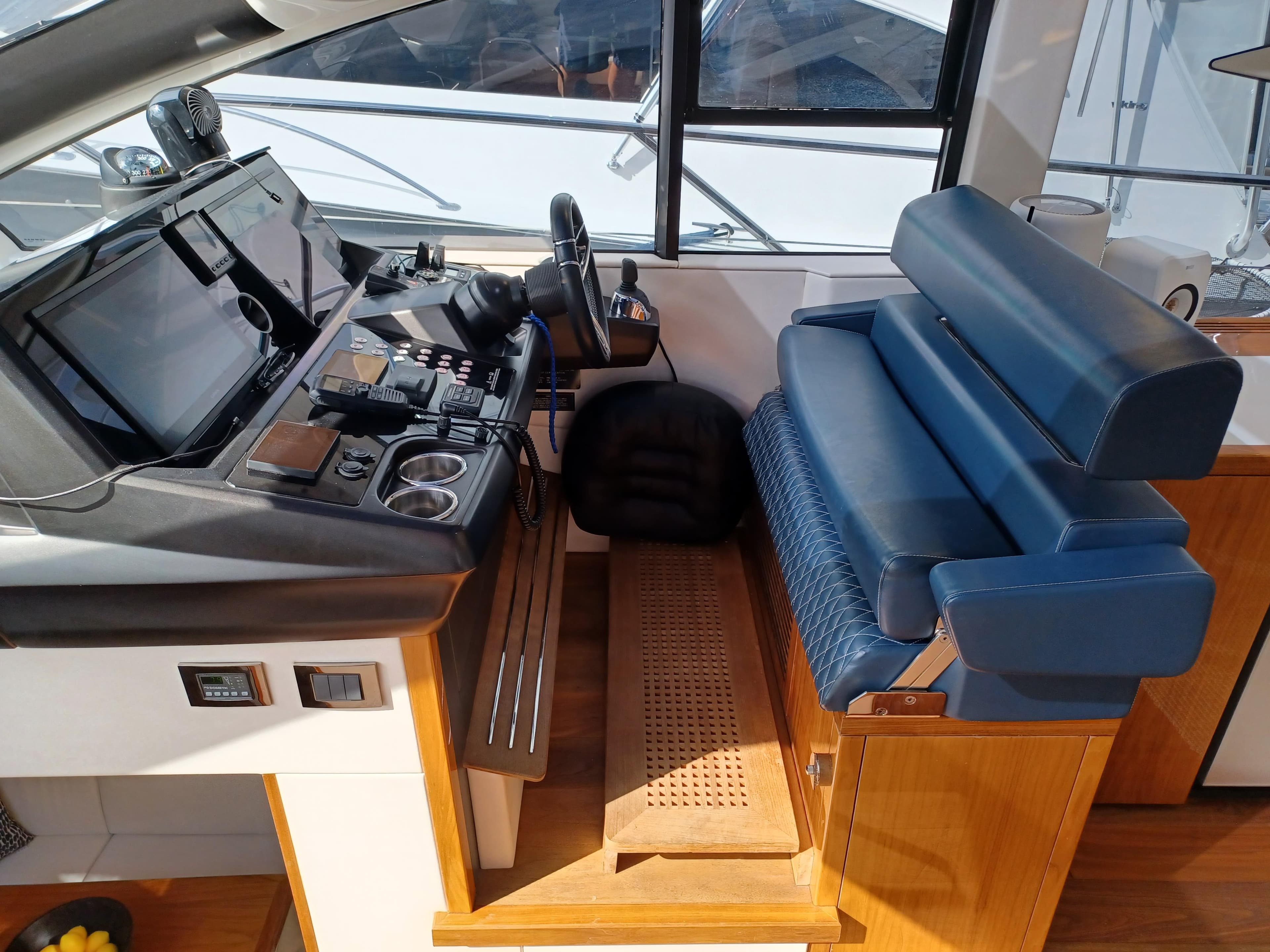 Helm station of 2020 Sunseeker Predator 50 yacht with modern controls and blue seating.