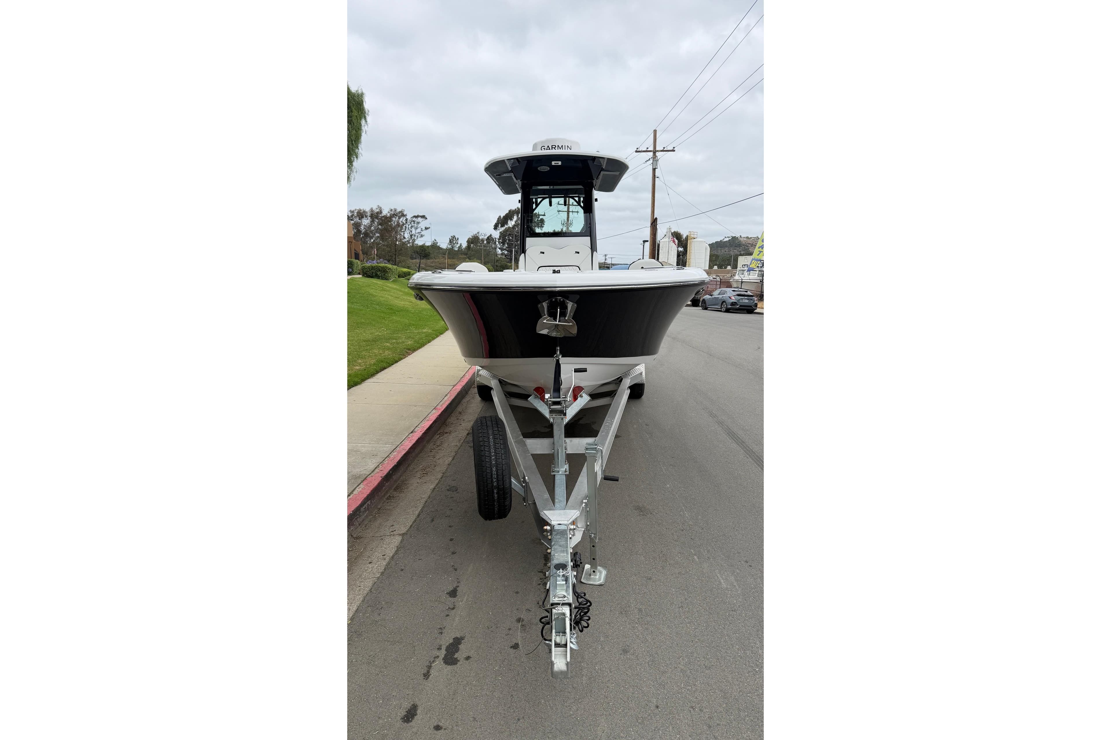 2026 Stingray 253 CC boat on trailer, parked on a street.