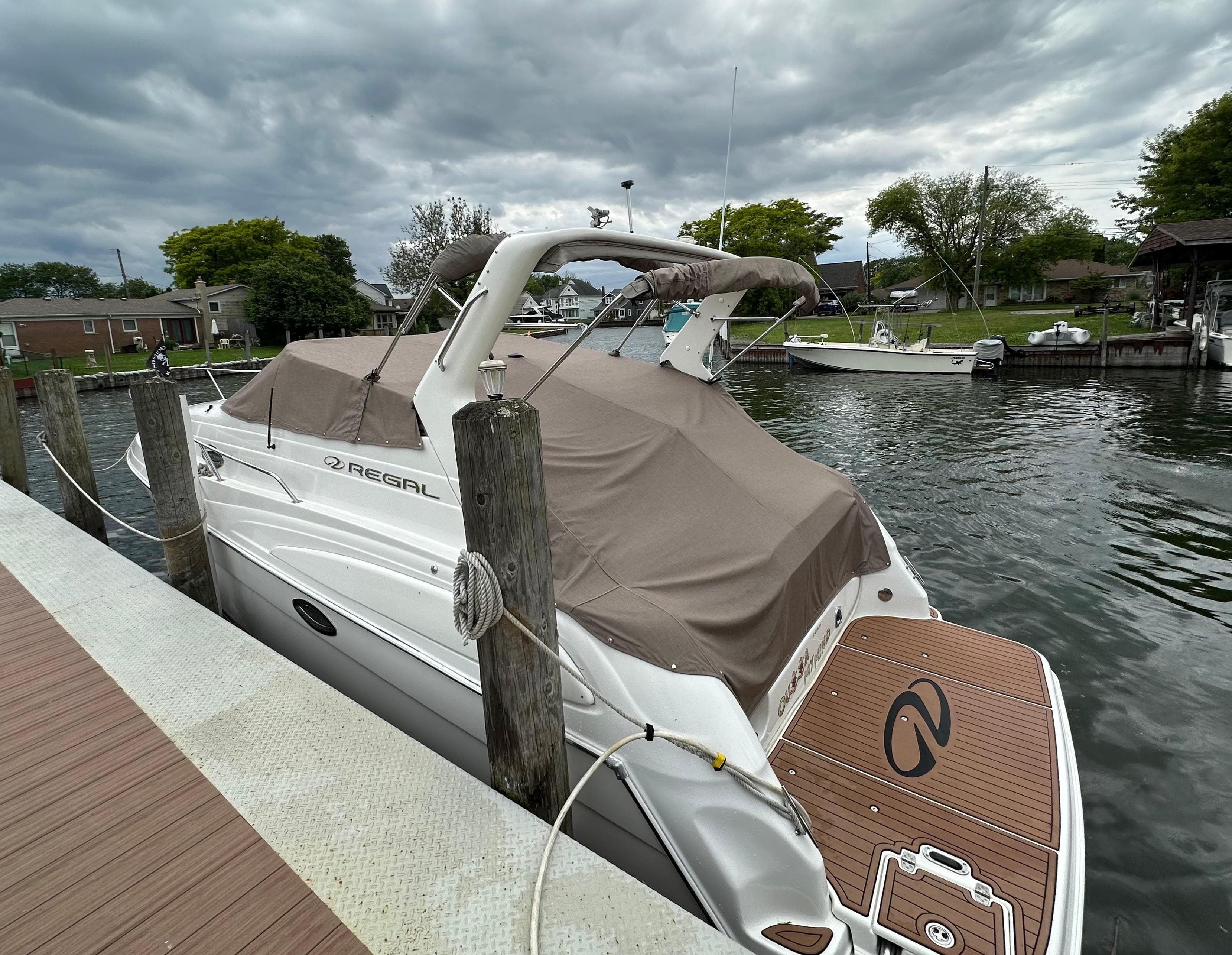 2003 Regal Commodore 2860 boat docked at a marina under cloudy skies.