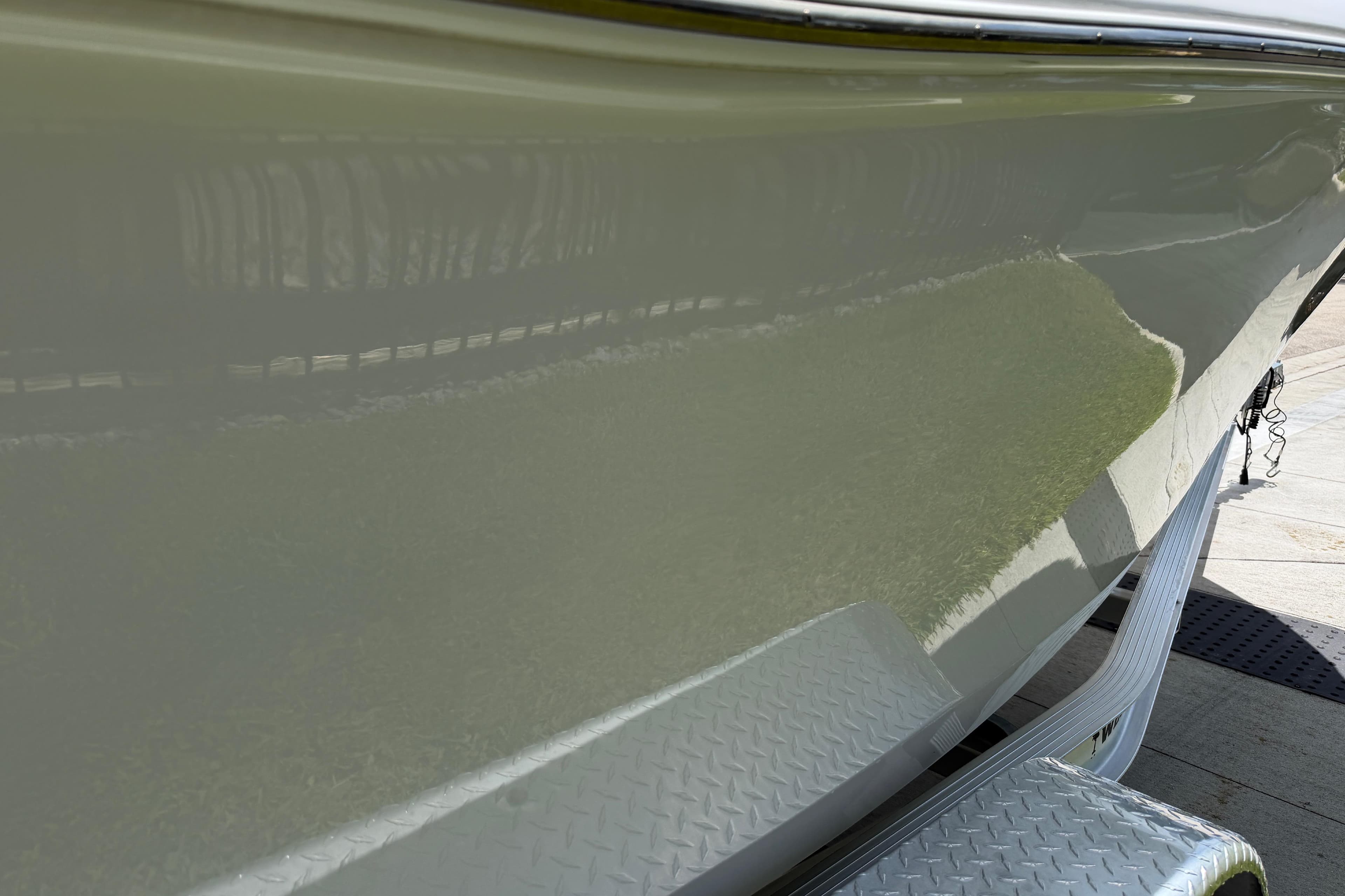 2023 Tidewater 198 CC Adventure boat hull on a trailer, reflecting sunlight.