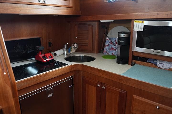 2006 Sabre 38 Hardtop Express galley with wood cabinetry, sink, stove, and microwave.
