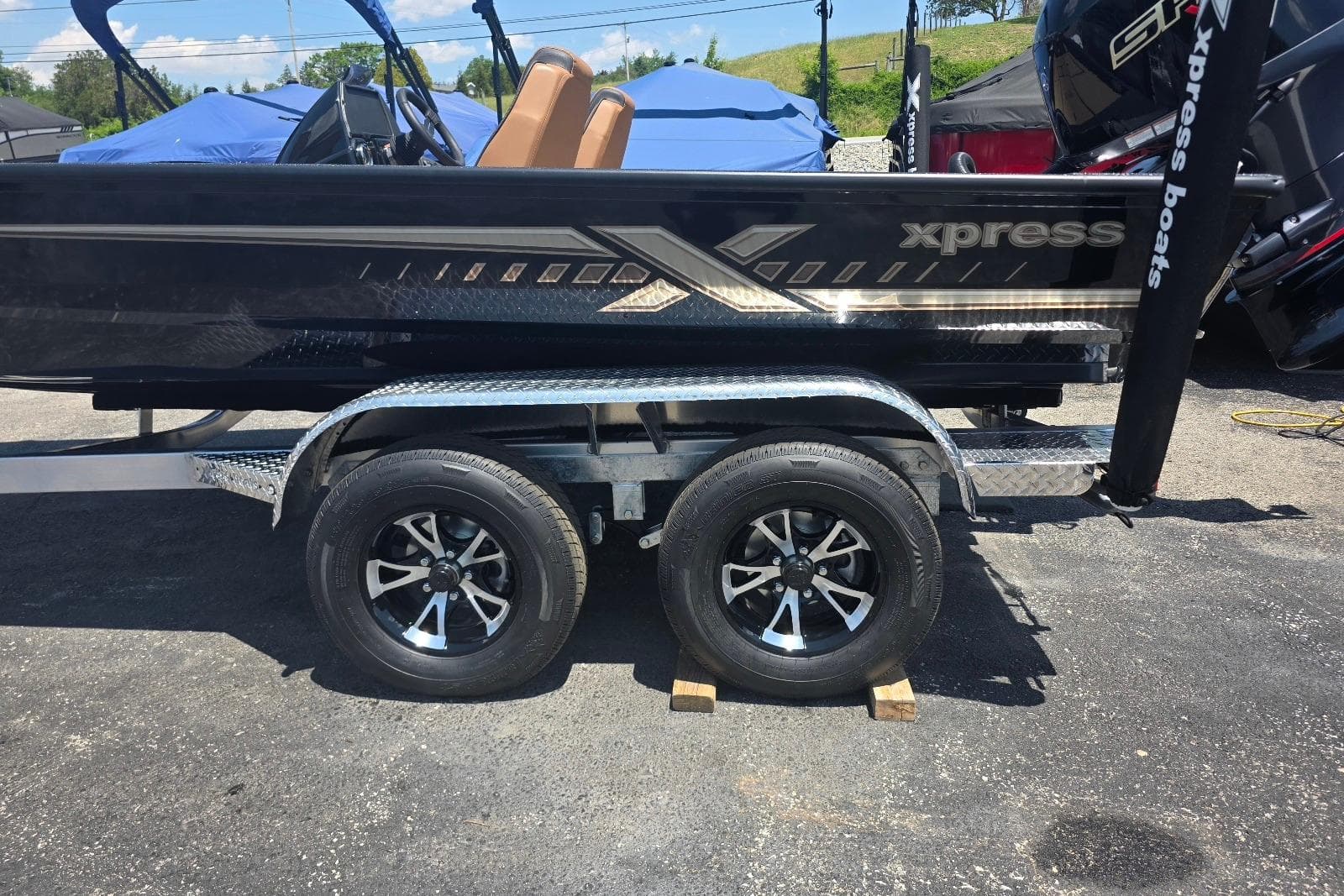 2026 Xpress H20C Crappie boat on trailer, featuring sleek black design and dual wheels.