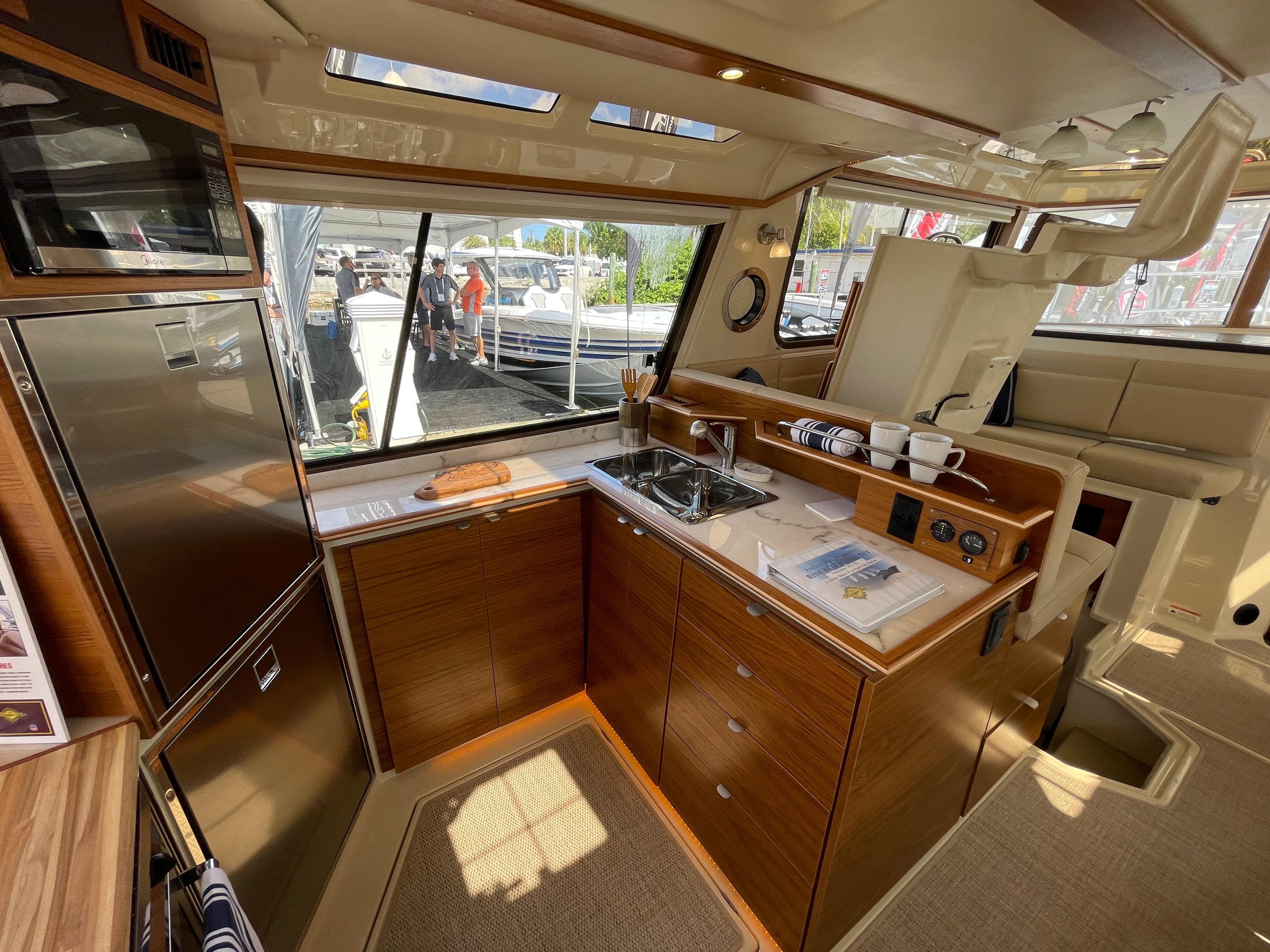 Interior of 2025 Ranger Tugs 43 Command Bridge, featuring a modern kitchen with wood cabinetry.