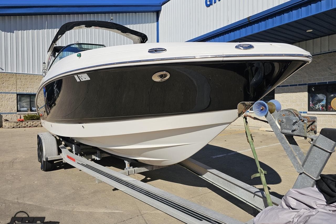 2010 Chaparral 276 SSX boat on trailer, parked outside a building.
