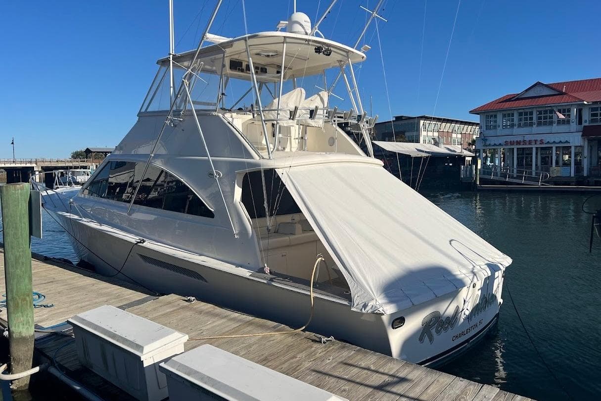 2002 Ocean Yachts 56 Super Sport docked at marina, sunny day, waterfront buildings.