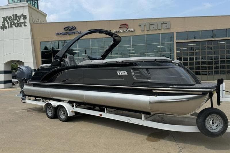 2025 Bennington 27 QXFBAT2 pontoon boat on trailer outside dealership.