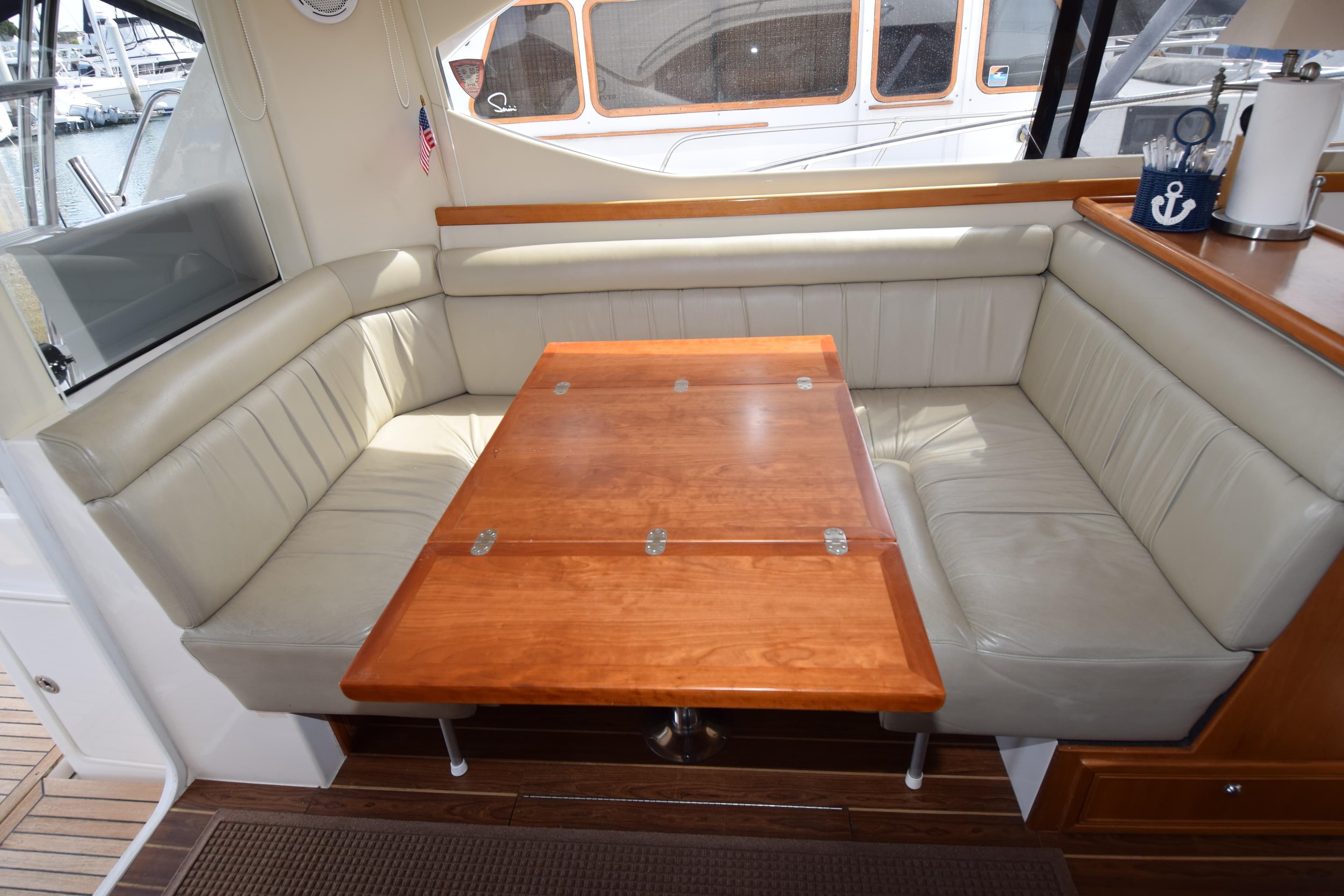 Luxurious interior of 2005 Riviera 33 Open Flybridge with plush seating and wooden table.