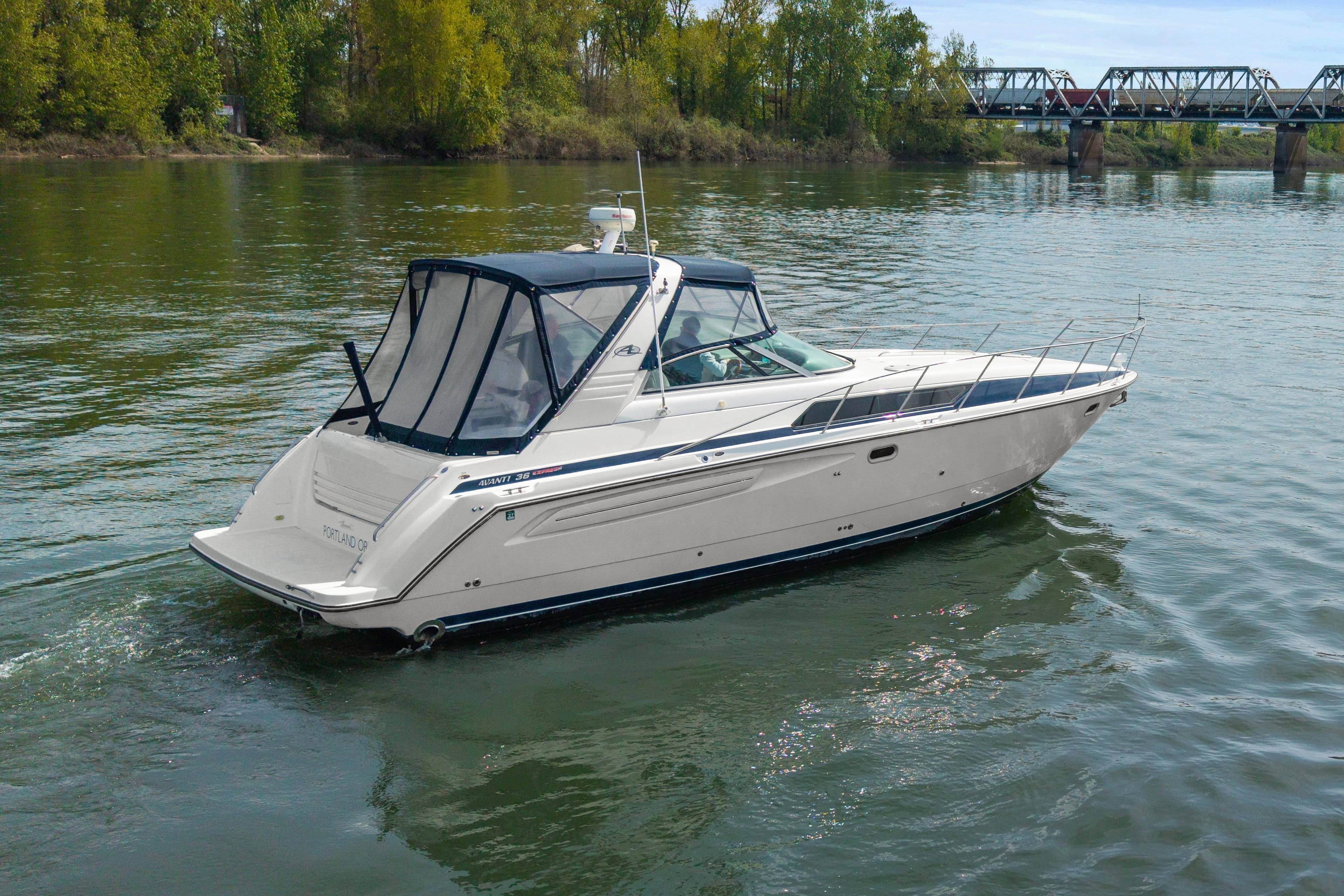 1998 Bayliner 3685 Avanti Sunbridge cruising on a scenic river.