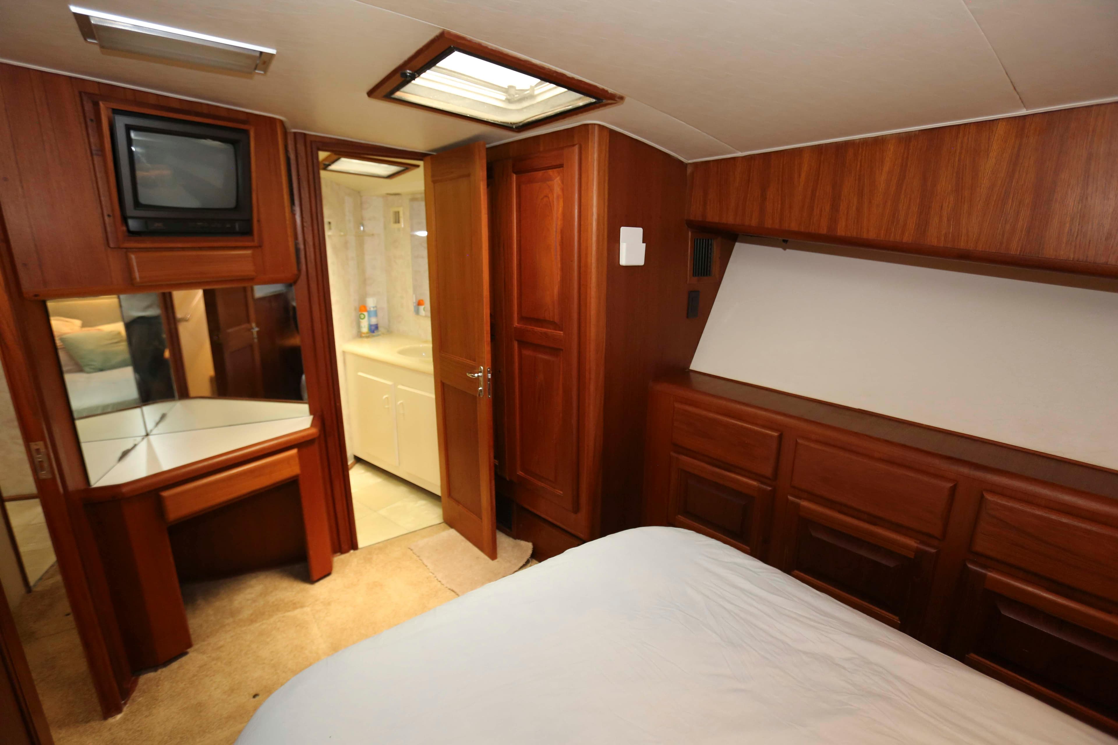 Interior of 1991 Viking 50 Convertible yacht with wood paneling and compact bathroom.