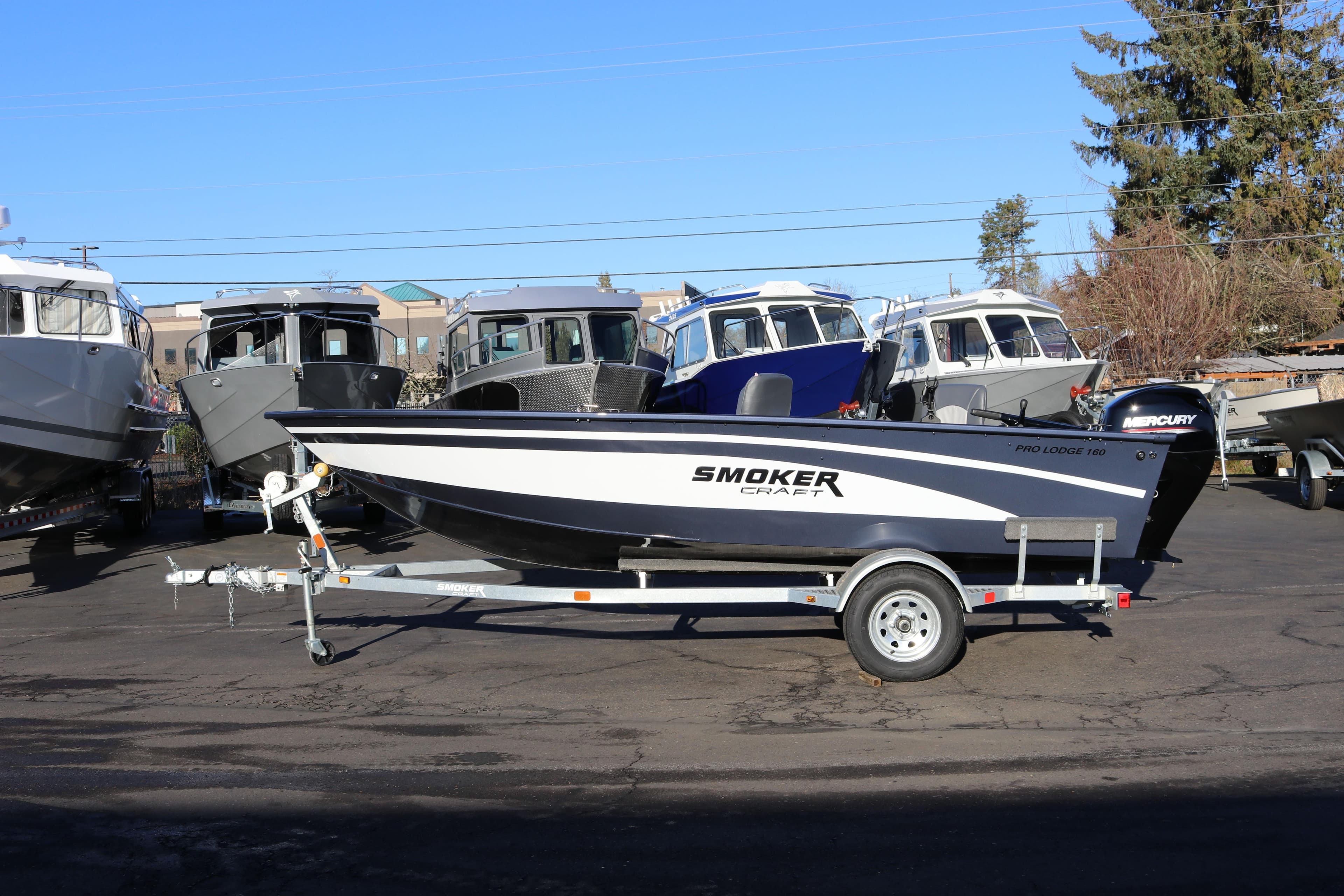 2026 Smoker Craft Pro Lodge 160 boat on trailer, parked outdoors.