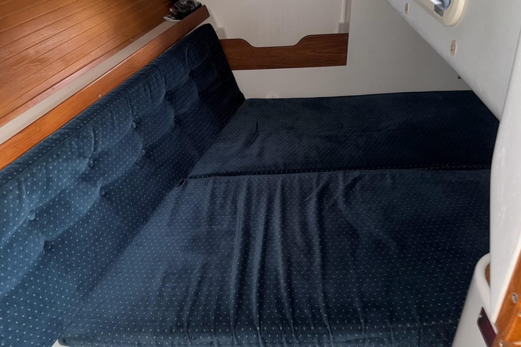 Interior cabin of a 1994 Catalina 320 sailboat with blue cushioned seating.