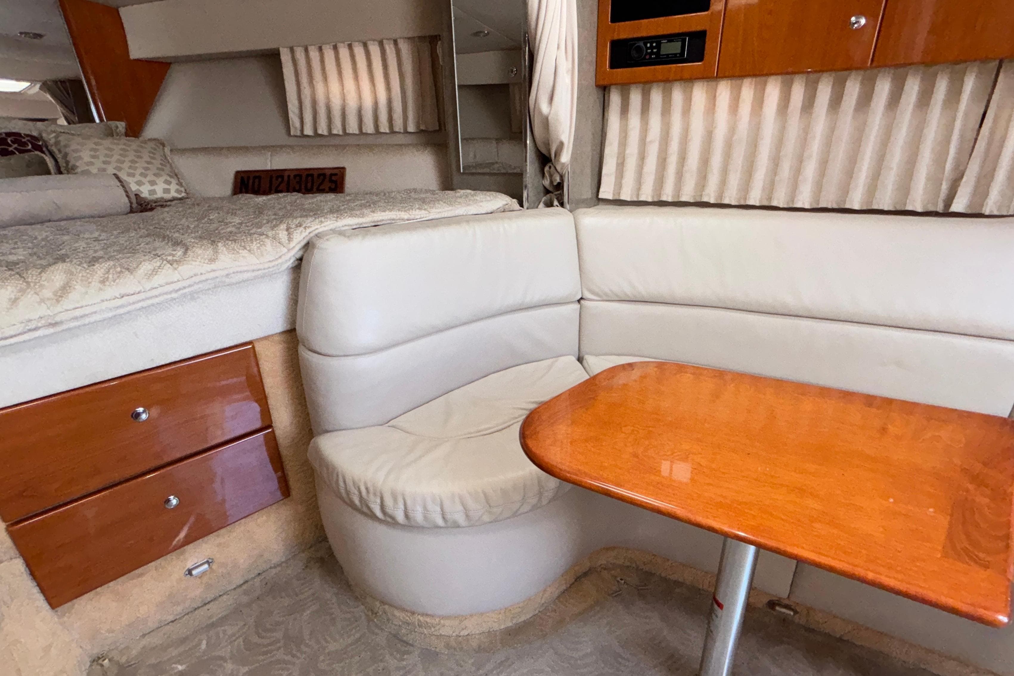 Interior of a 2005 Formula 31 Performance Cruiser with seating and wooden table.