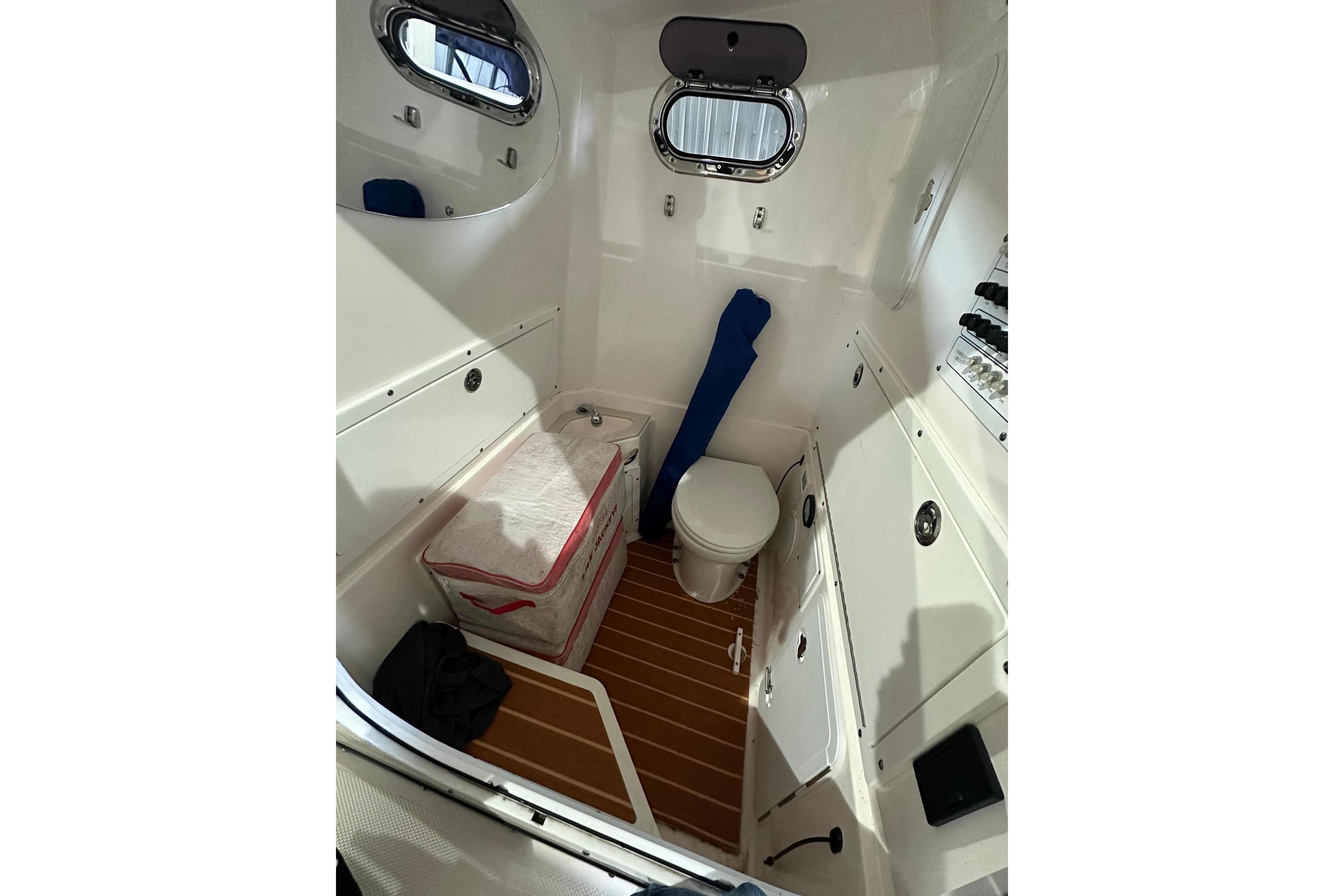 Interior of 2015 Edgewater 320CC boat featuring a compact marine toilet.