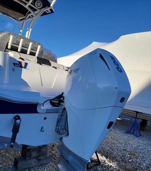 2023 Wellcraft 222 Fisherman boat with powerful outboard motor, parked on gravel.