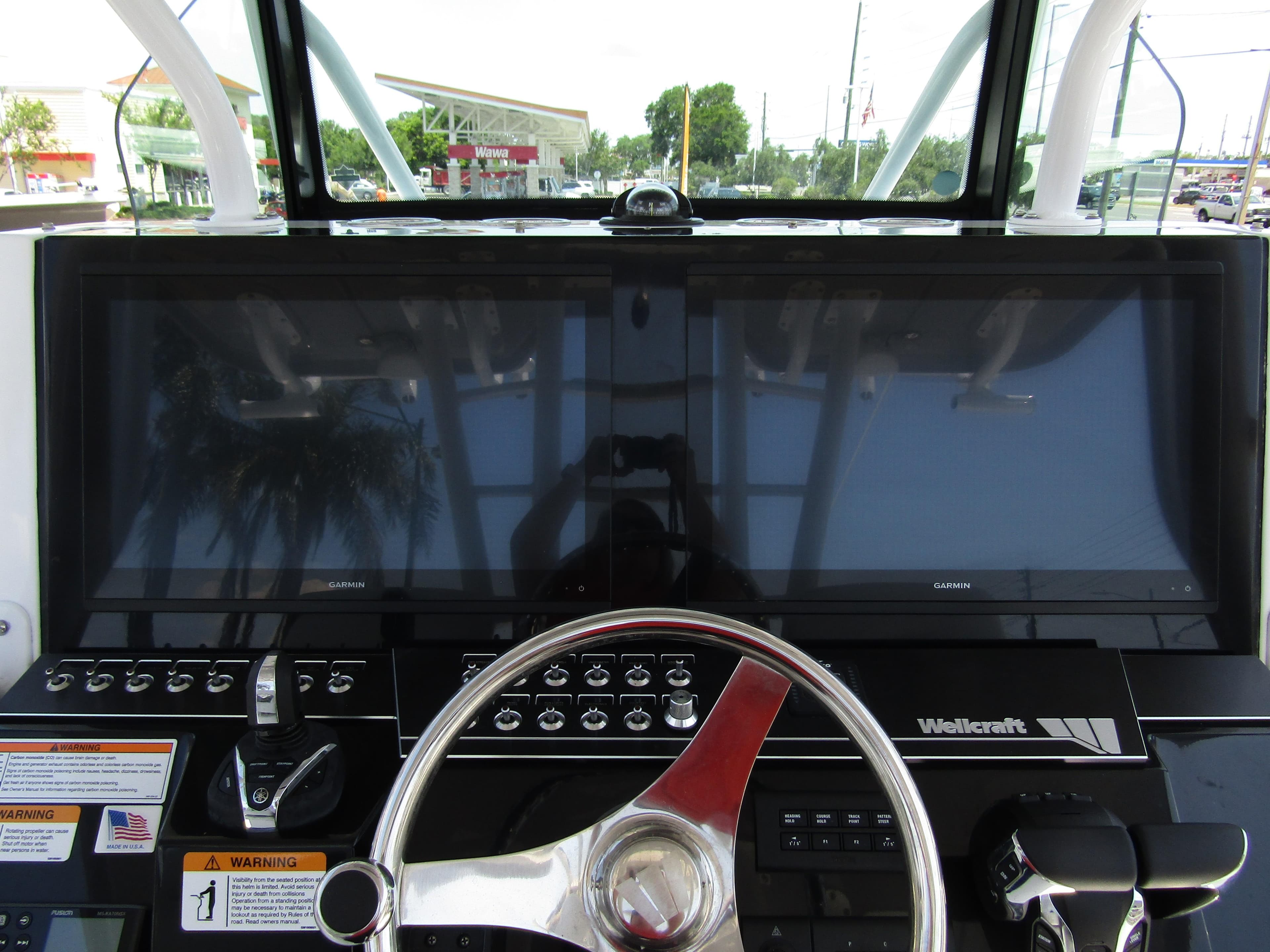 2024 Wellcraft 352 Fisherman boat dashboard with dual Garmin displays and steering wheel.