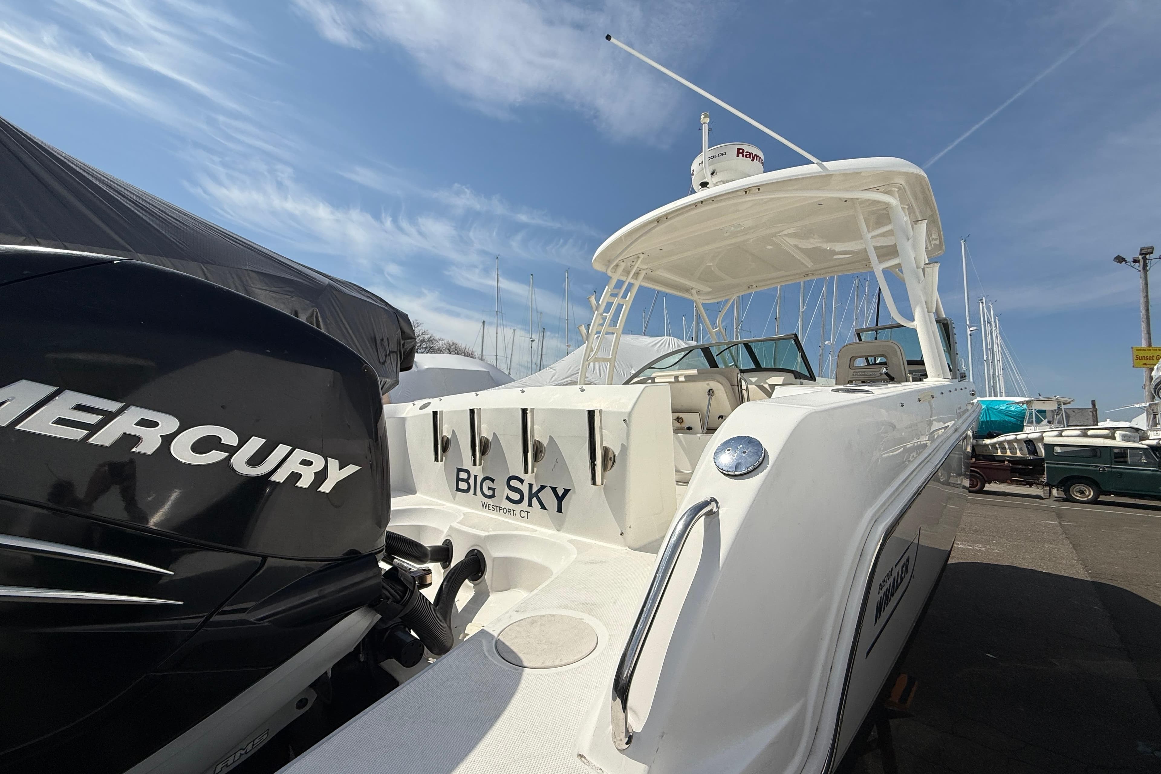 2016 Boston Whaler 270 Vantage boat with Mercury engine, docked under clear blue sky.