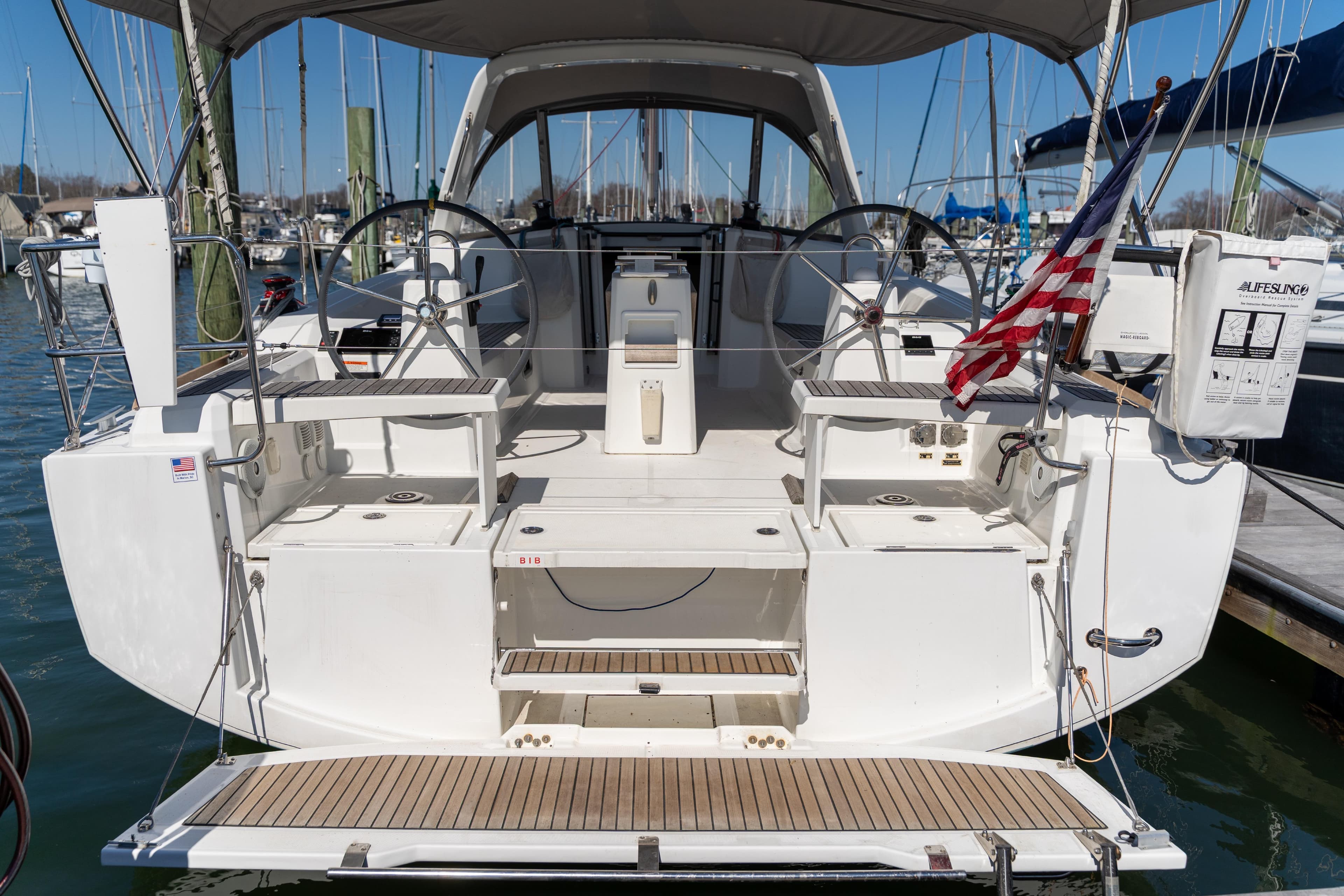2018 Beneteau Oceanis 38.1 sailboat with dual steering wheels and American flag.