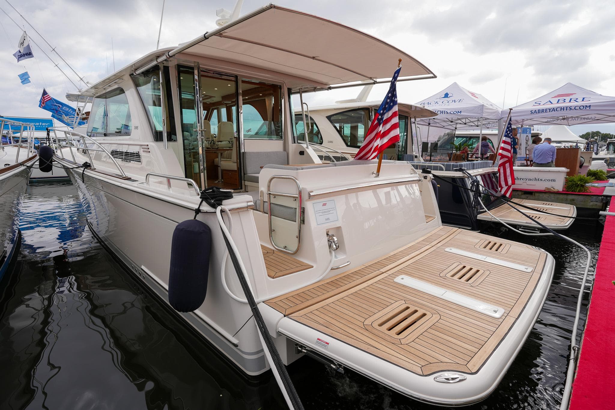 2026 Sabre 45 Salon Express yacht docked, featuring a spacious deck and American flag.