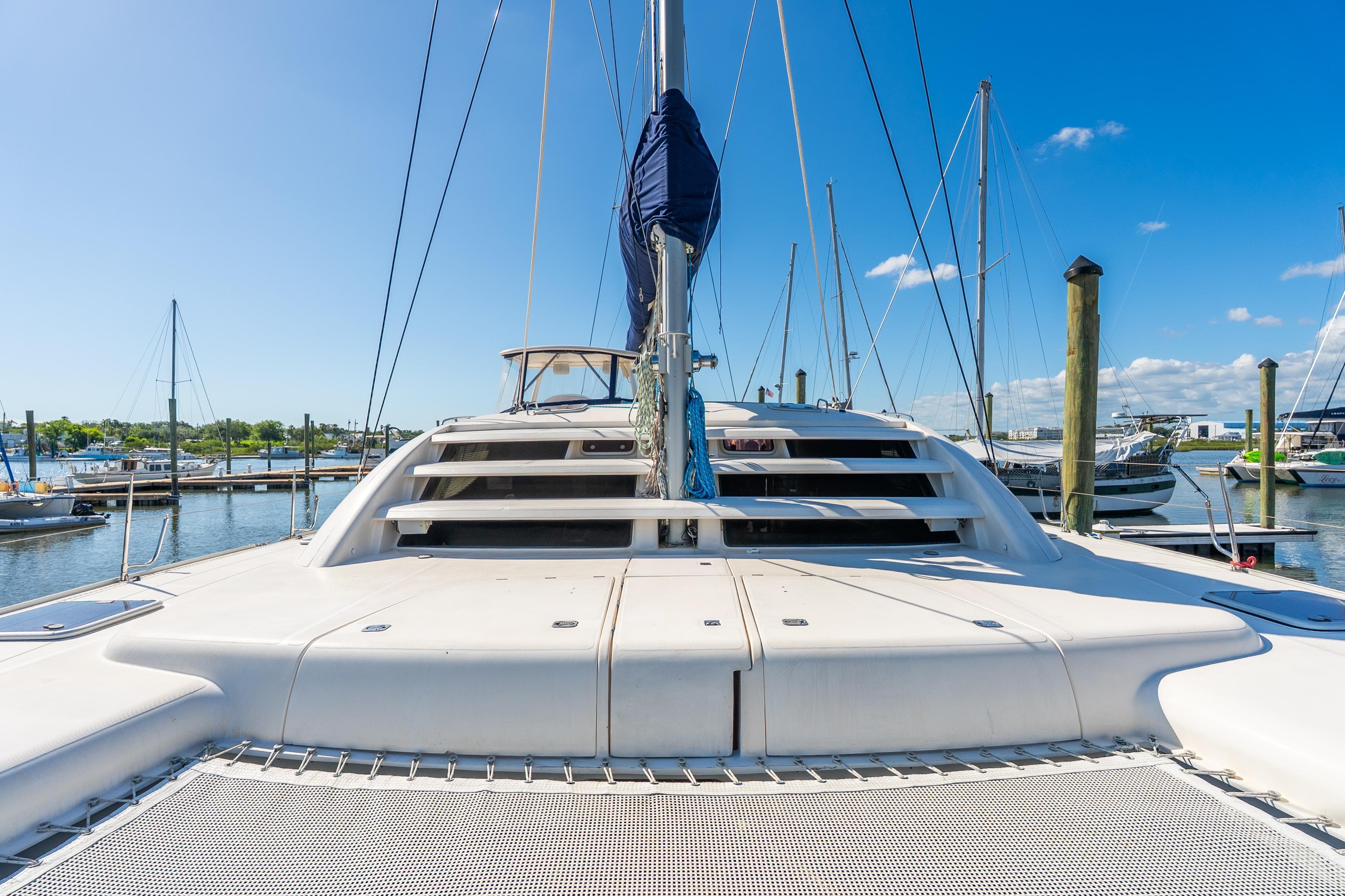 2007 Leopard 46 catamaran docked at marina under clear blue sky.