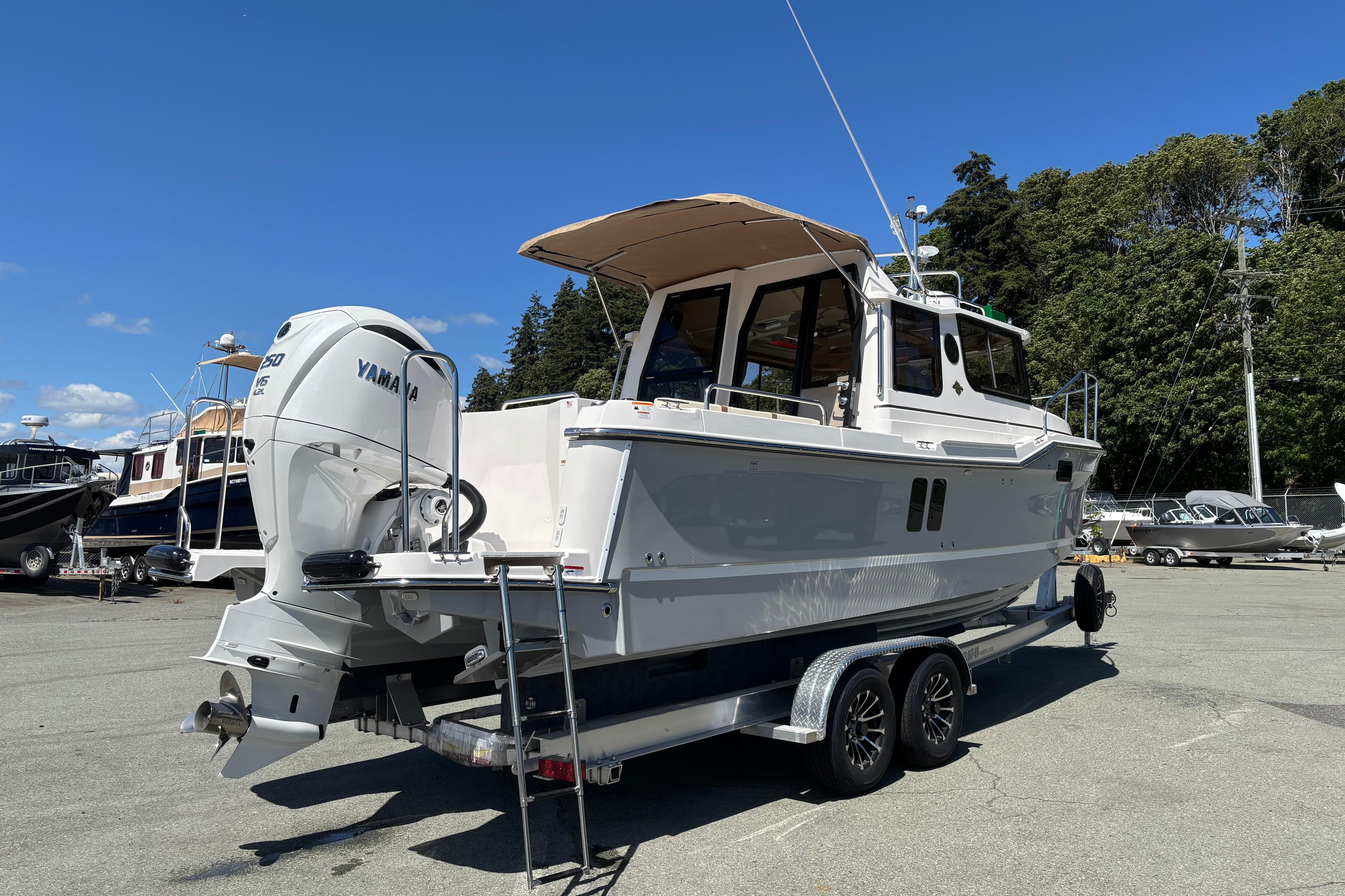 2026 Ranger Tugs R-25 boat on trailer, featuring Yamaha outboard motor, parked outdoors.