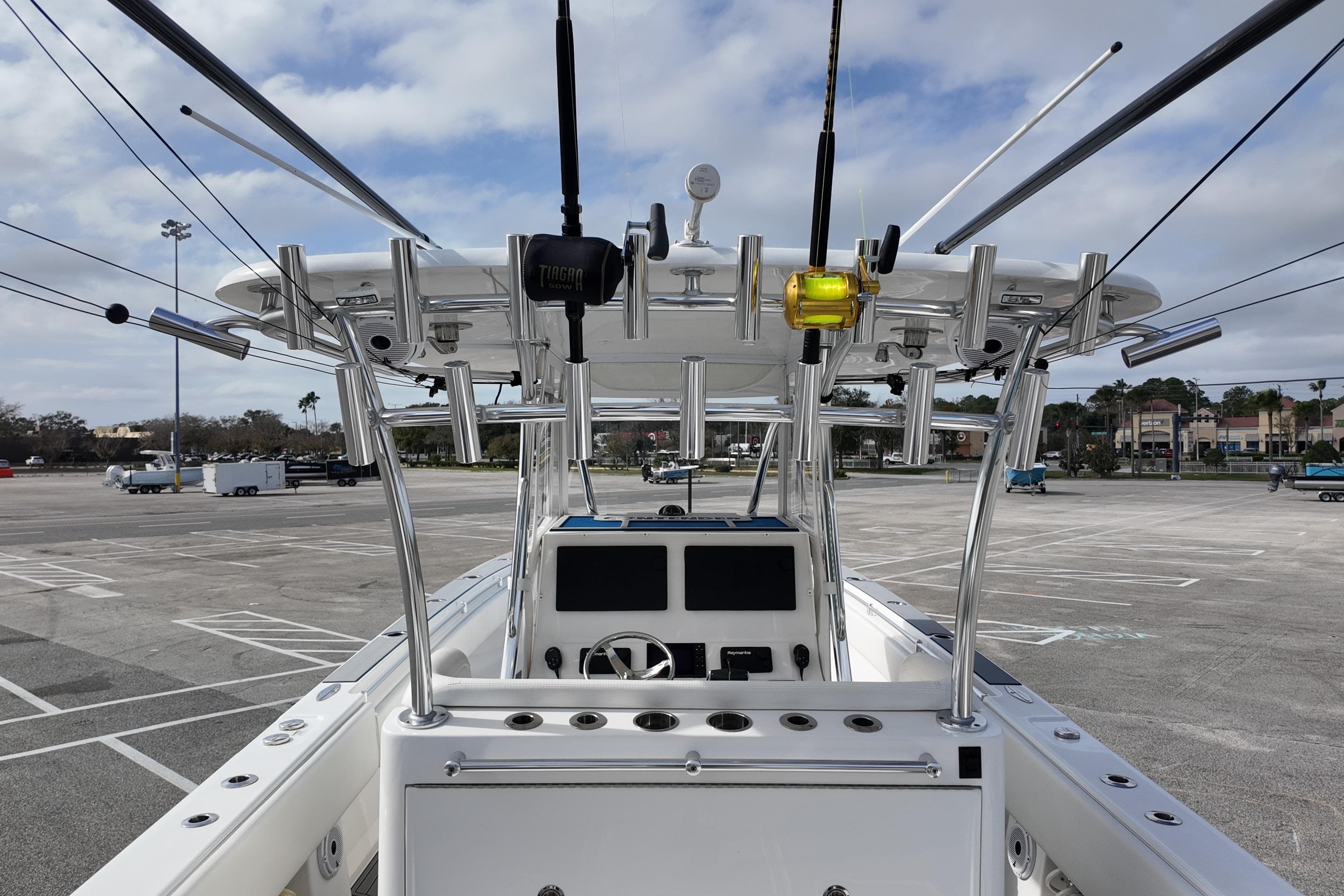 2024 Contender 39 ST boat with fishing rods and console in a parking lot.