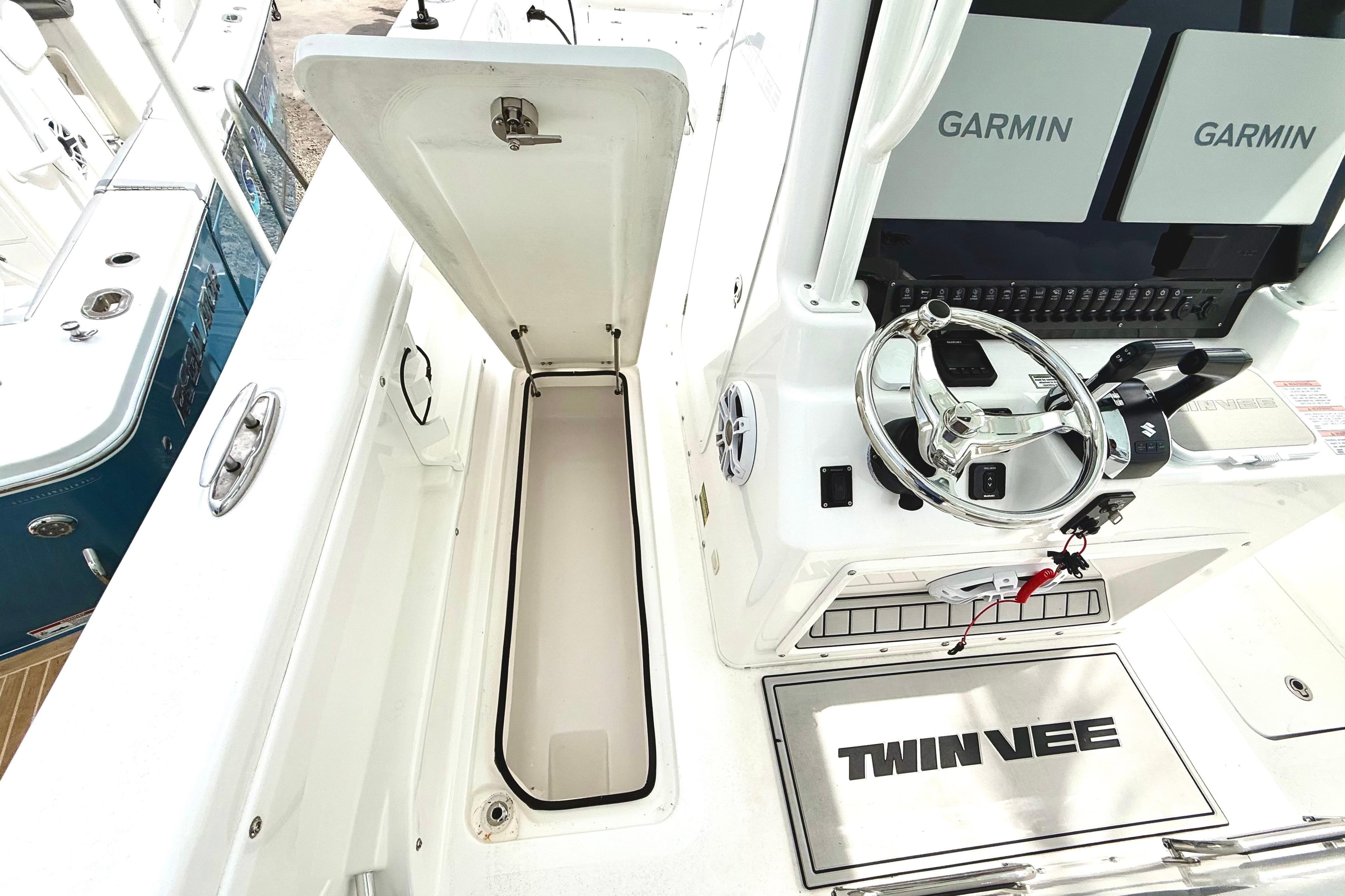 2022 Twin Vee 280 GFX CC boat interior with Garmin displays and storage compartment.
