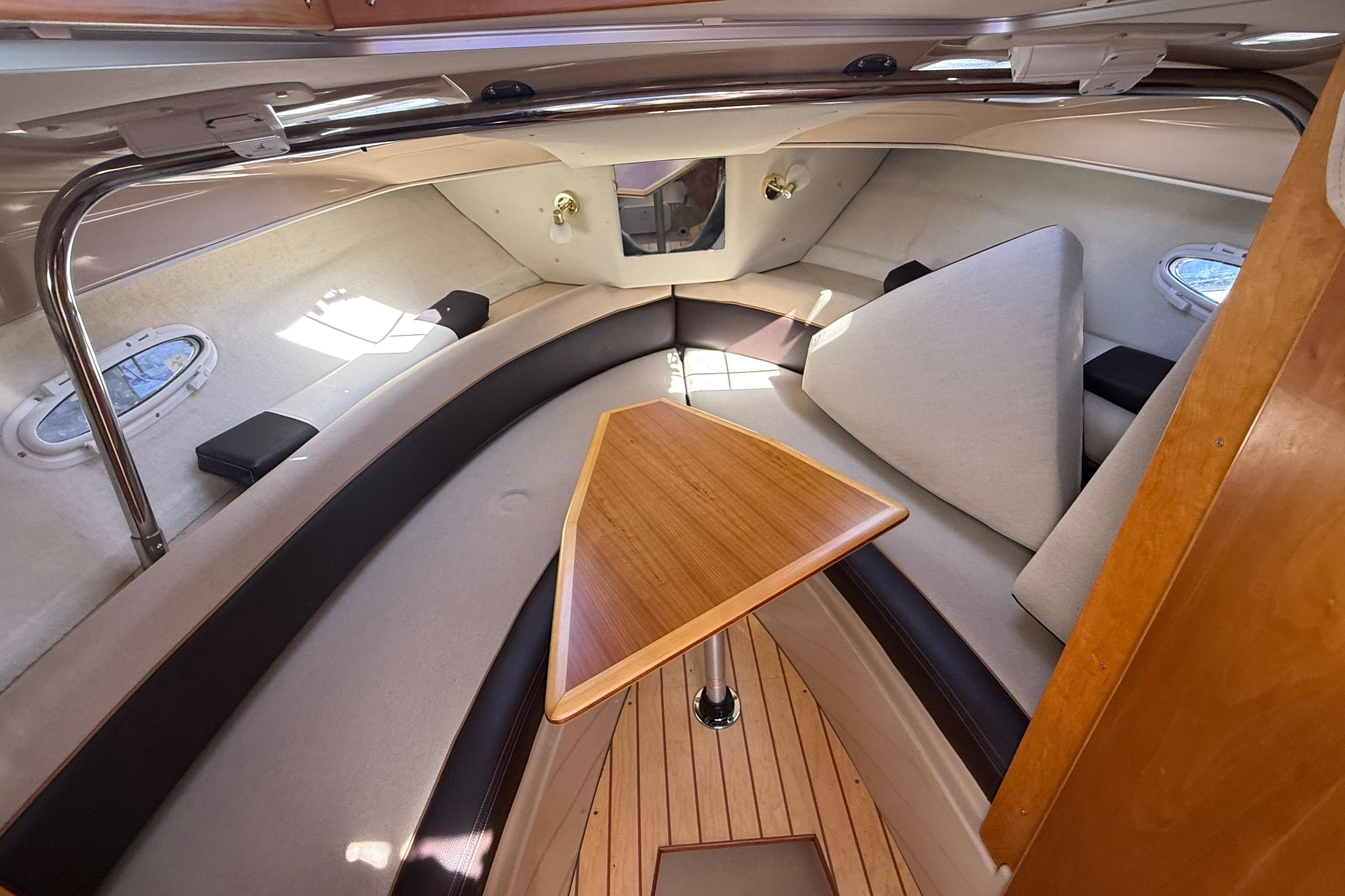 Interior of a 2016 Cutwater 24 boat with seating and wooden table.