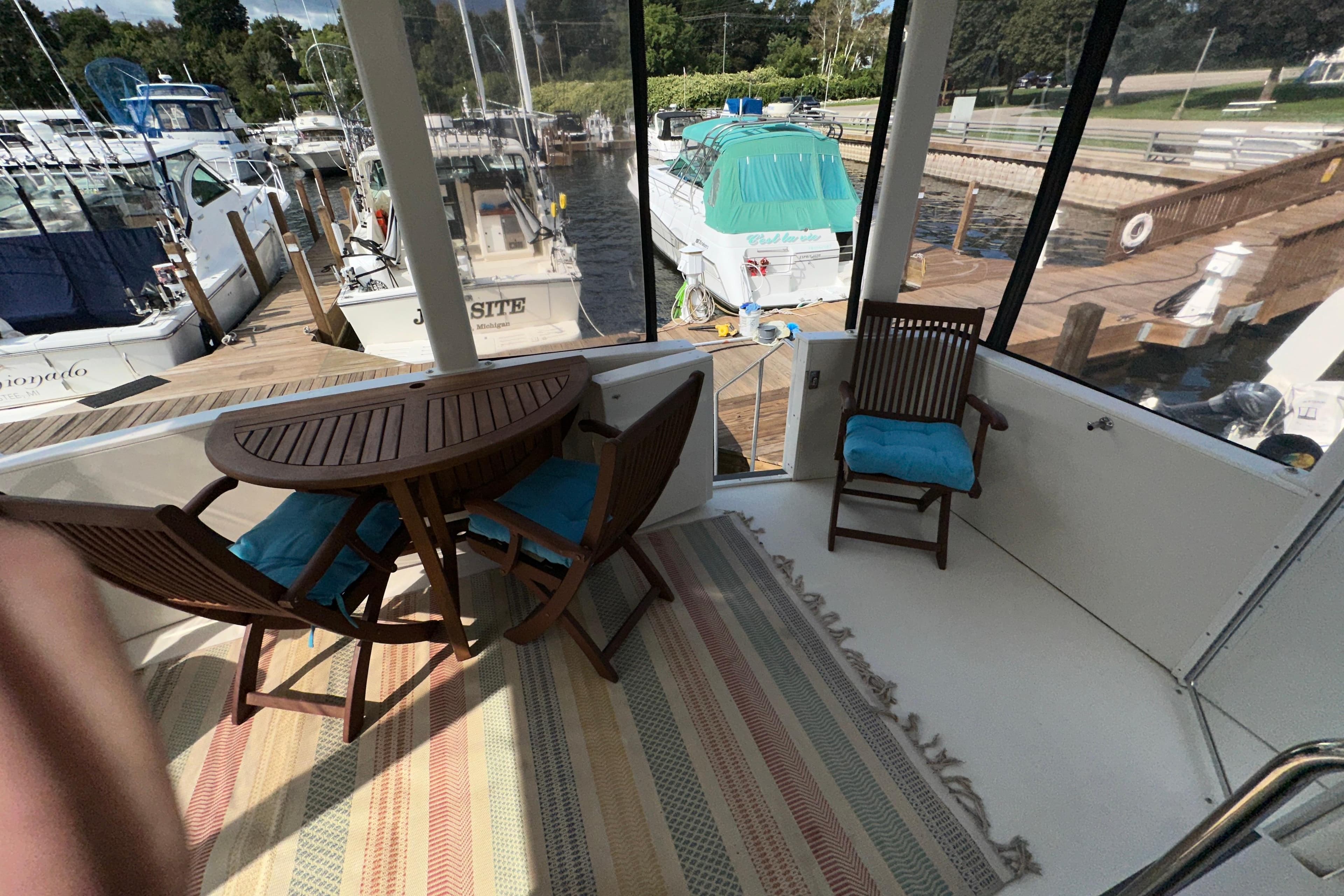 1998 Carver 445 Aft Cabin Motor Yacht with outdoor seating and marina view.