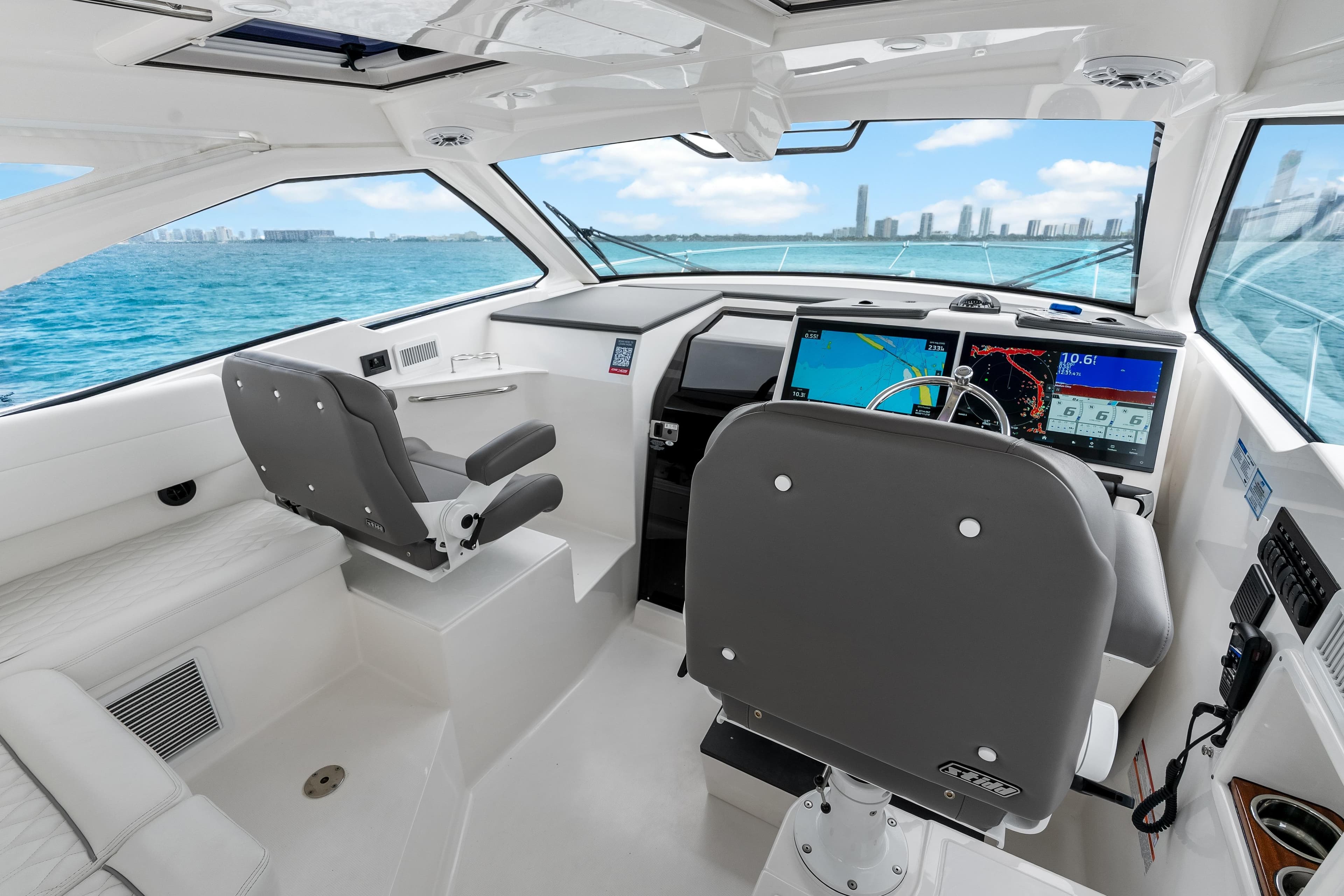 Helm of 2026 Pursuit OS 405 Offshore boat with modern navigation displays.