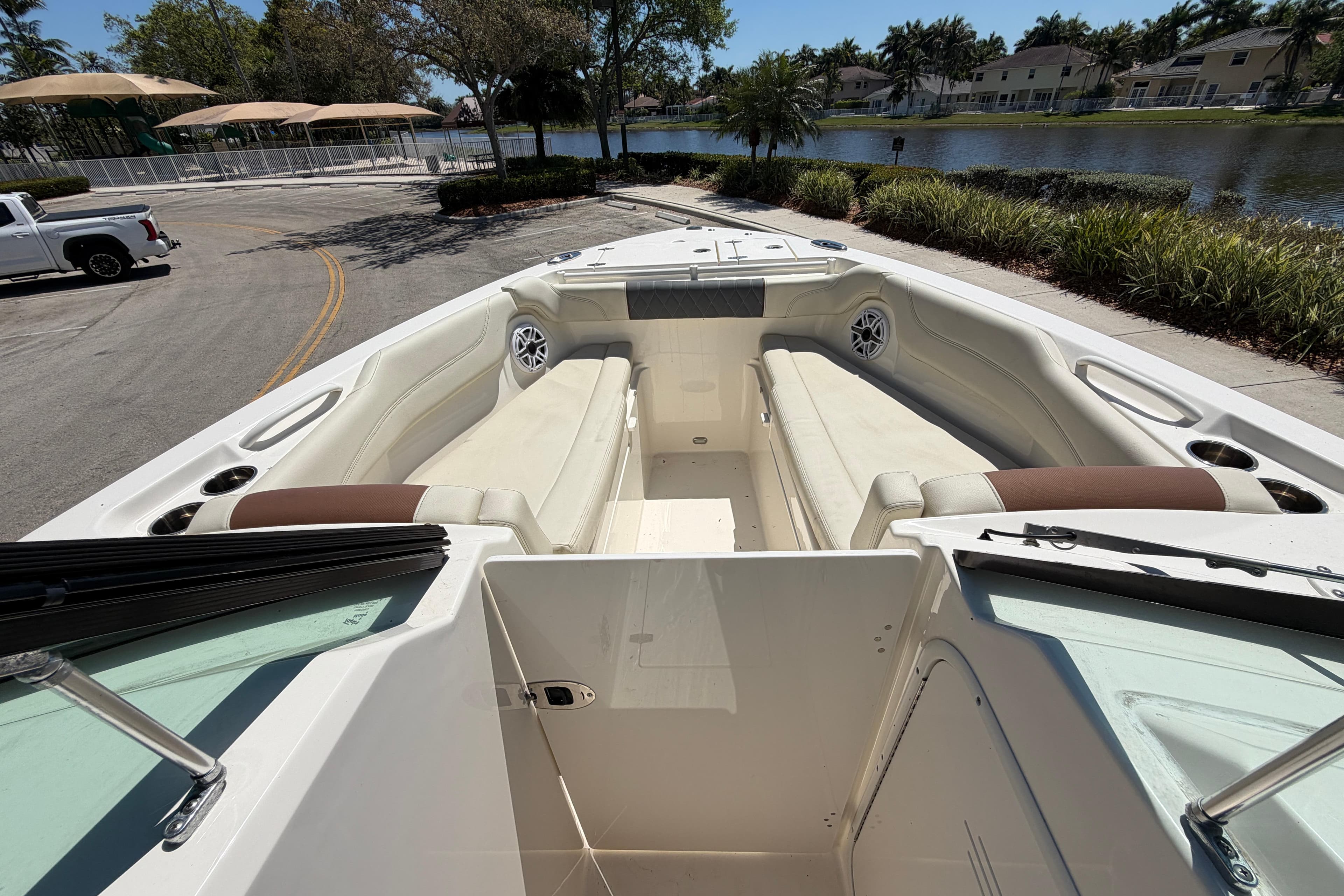 2021 Cobia 280 Dual Console boat with spacious seating, parked near a scenic waterfront.