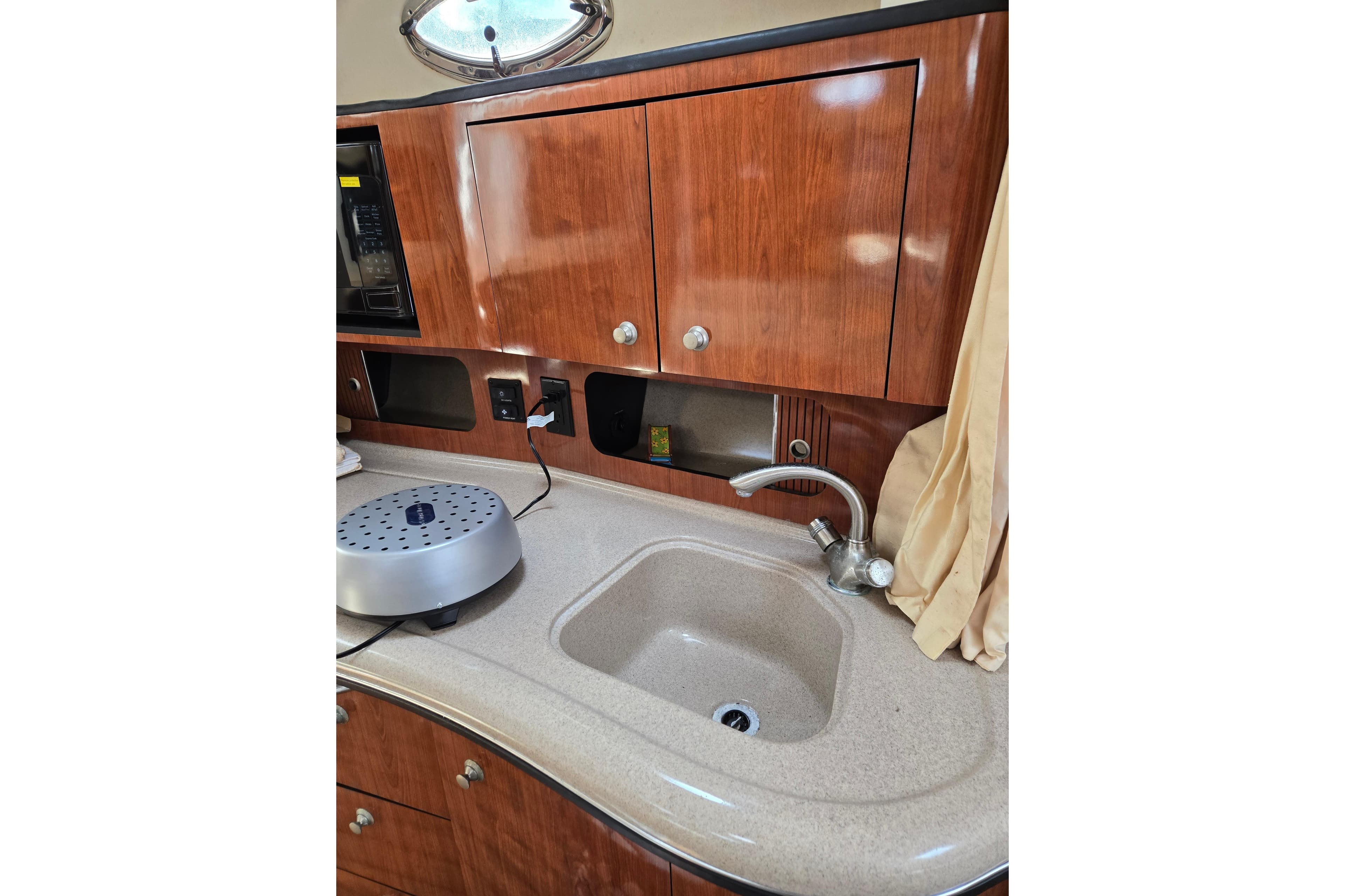 2006 Sea Ray Sundancer 320 galley with wooden cabinets and sink.
