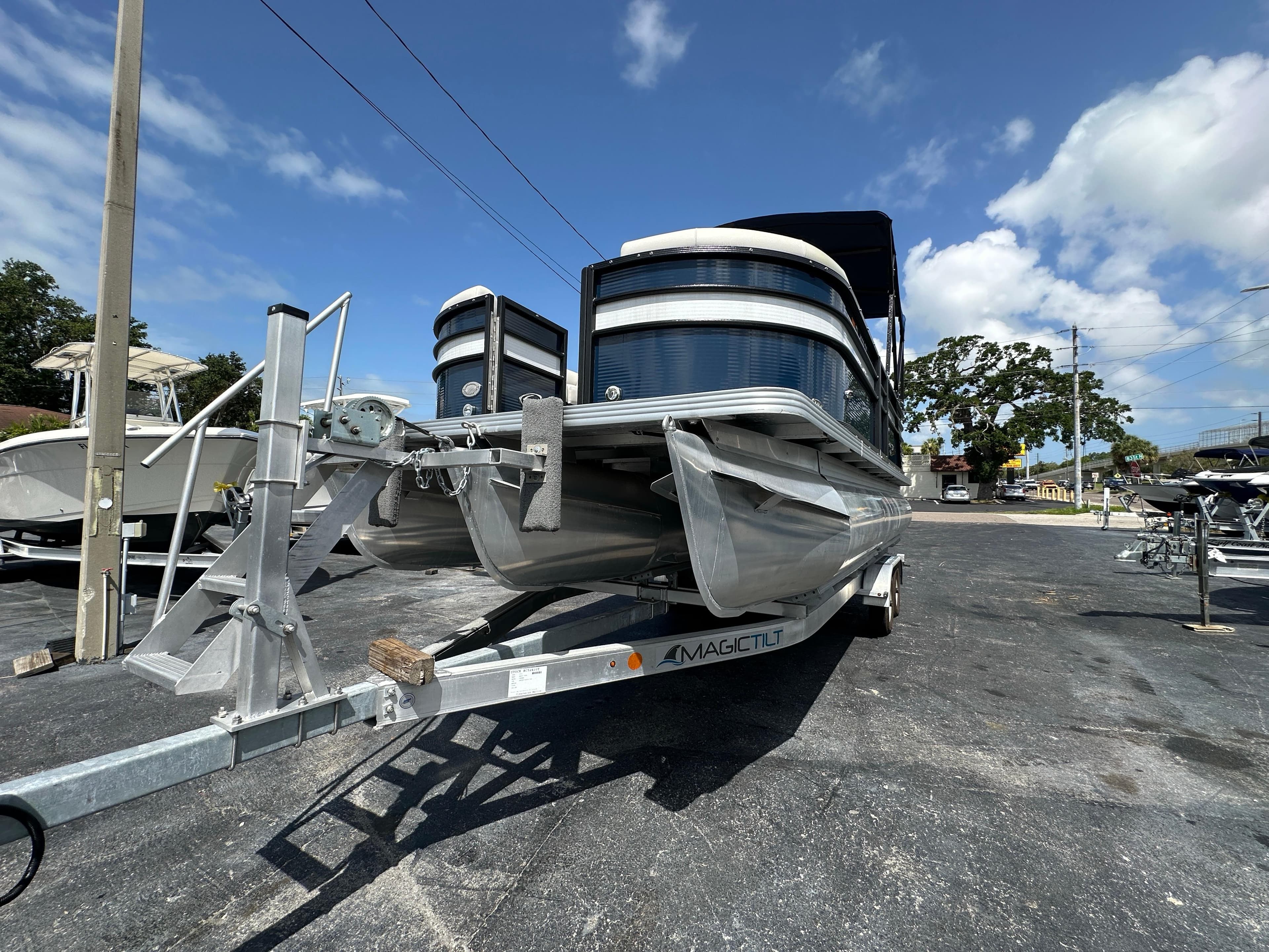 2022 Crest Classic DLX 220 pontoon boat on trailer under clear blue sky.