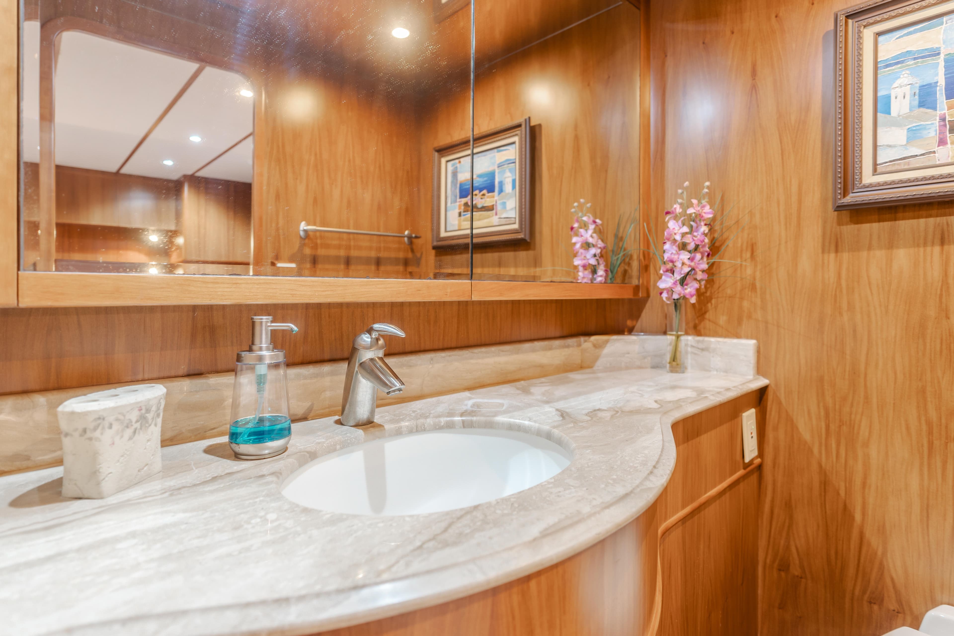 Luxurious wooden bathroom vanity with marble countertop, modern faucet, and decorative elements in a 2003 TransWorld CUSTOM.