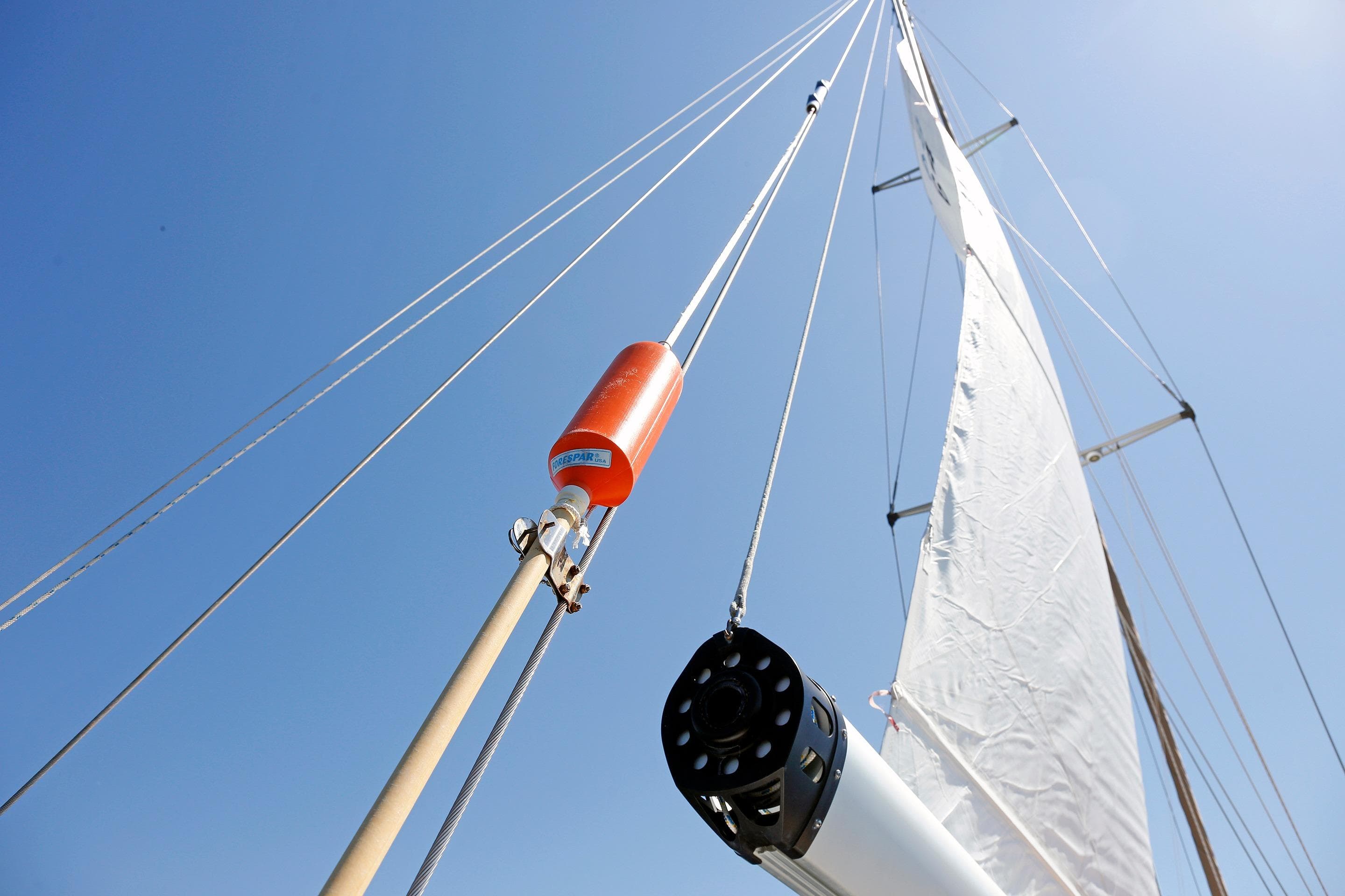 Sailboat mast and rigging of 2012 Hylas 49CC against clear blue sky.