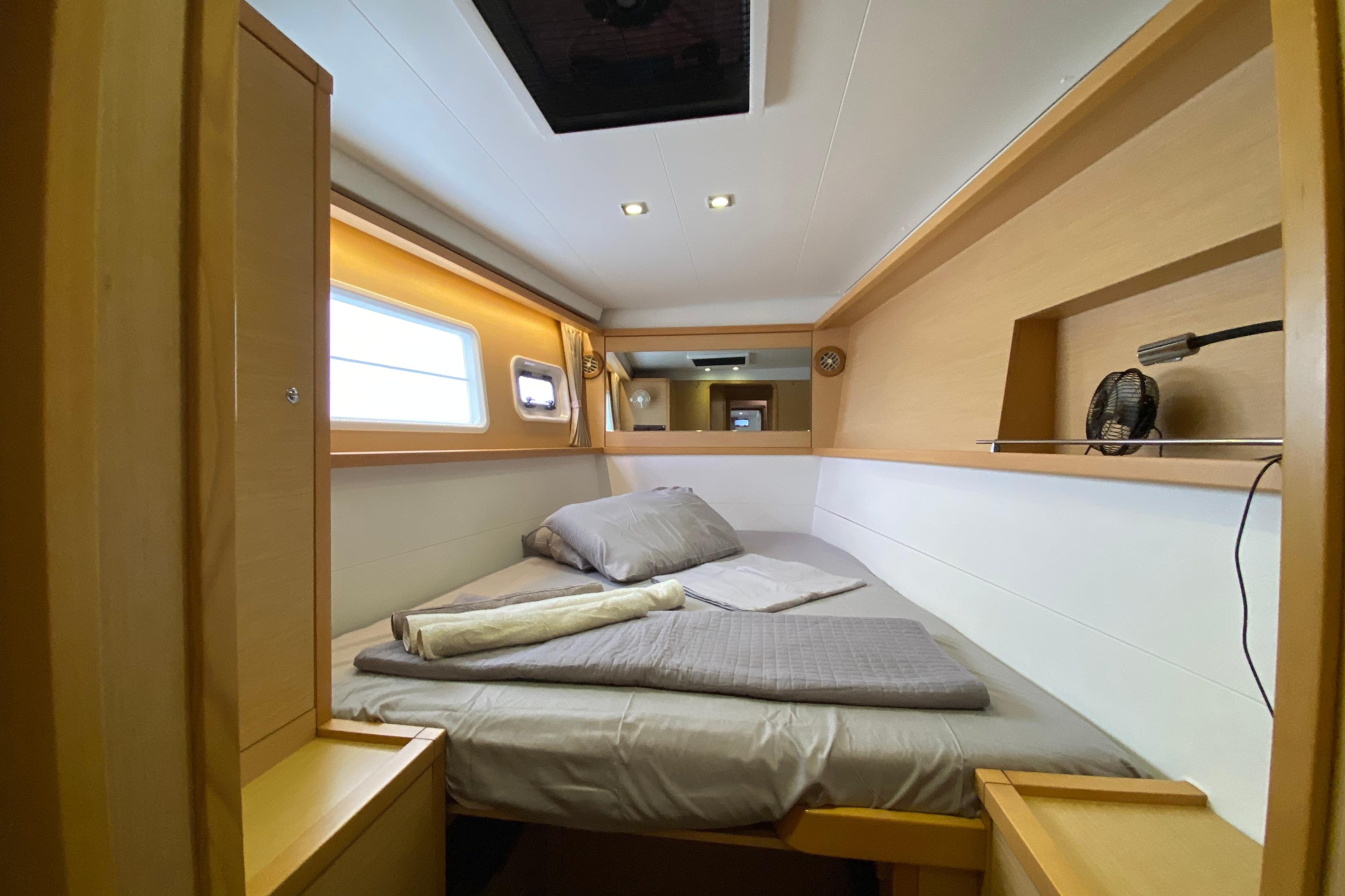 Cozy cabin interior of 2015 Lagoon 450 F catamaran with bed and window.