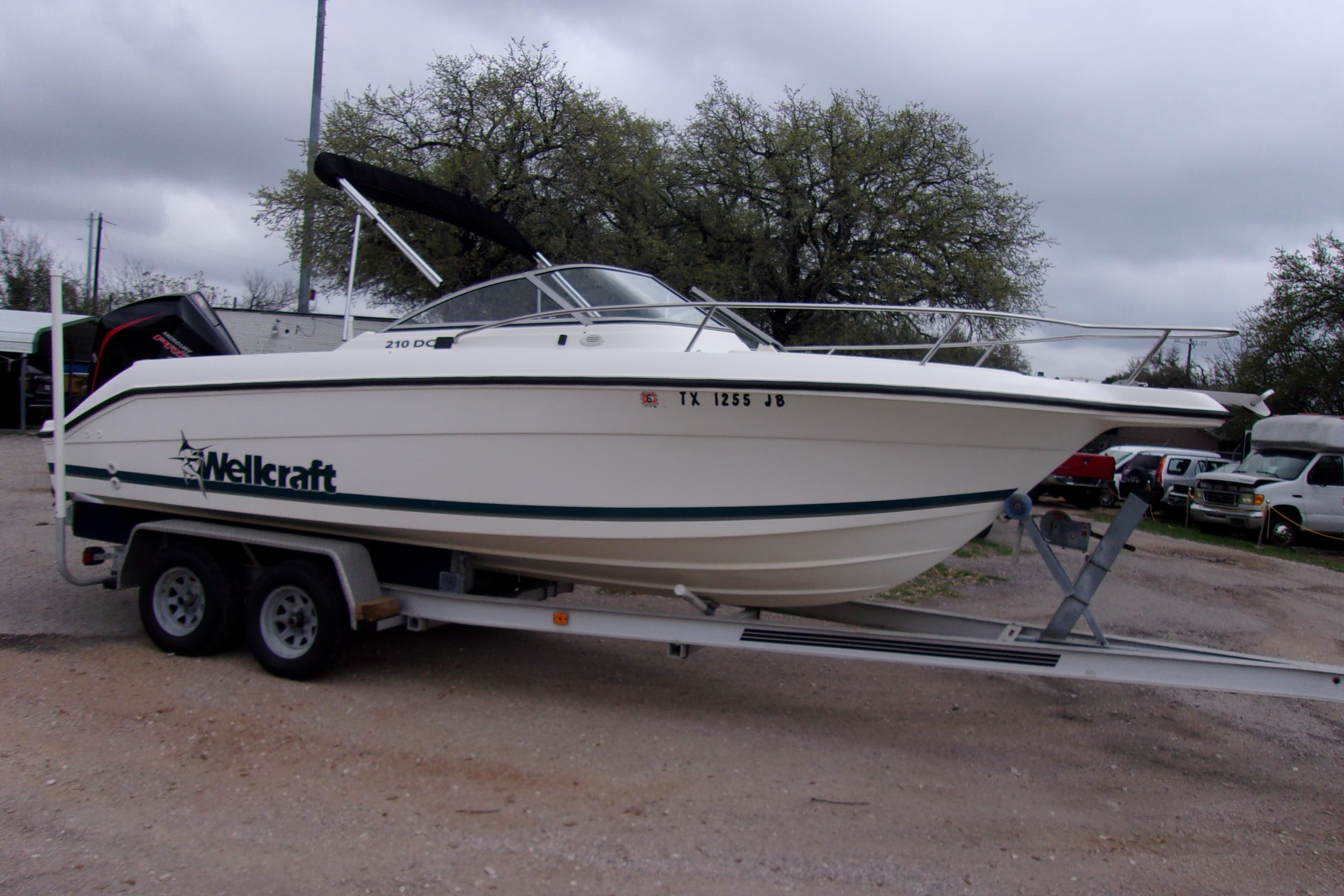1998 Wellcraft 210 Sportsman boat on trailer, parked outdoors.