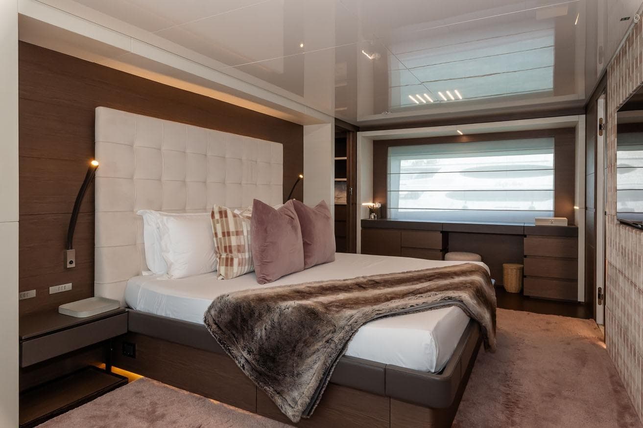 Luxurious bedroom interior on 2018 FERETTI Navetta 37 yacht, featuring elegant decor and plush bedding.