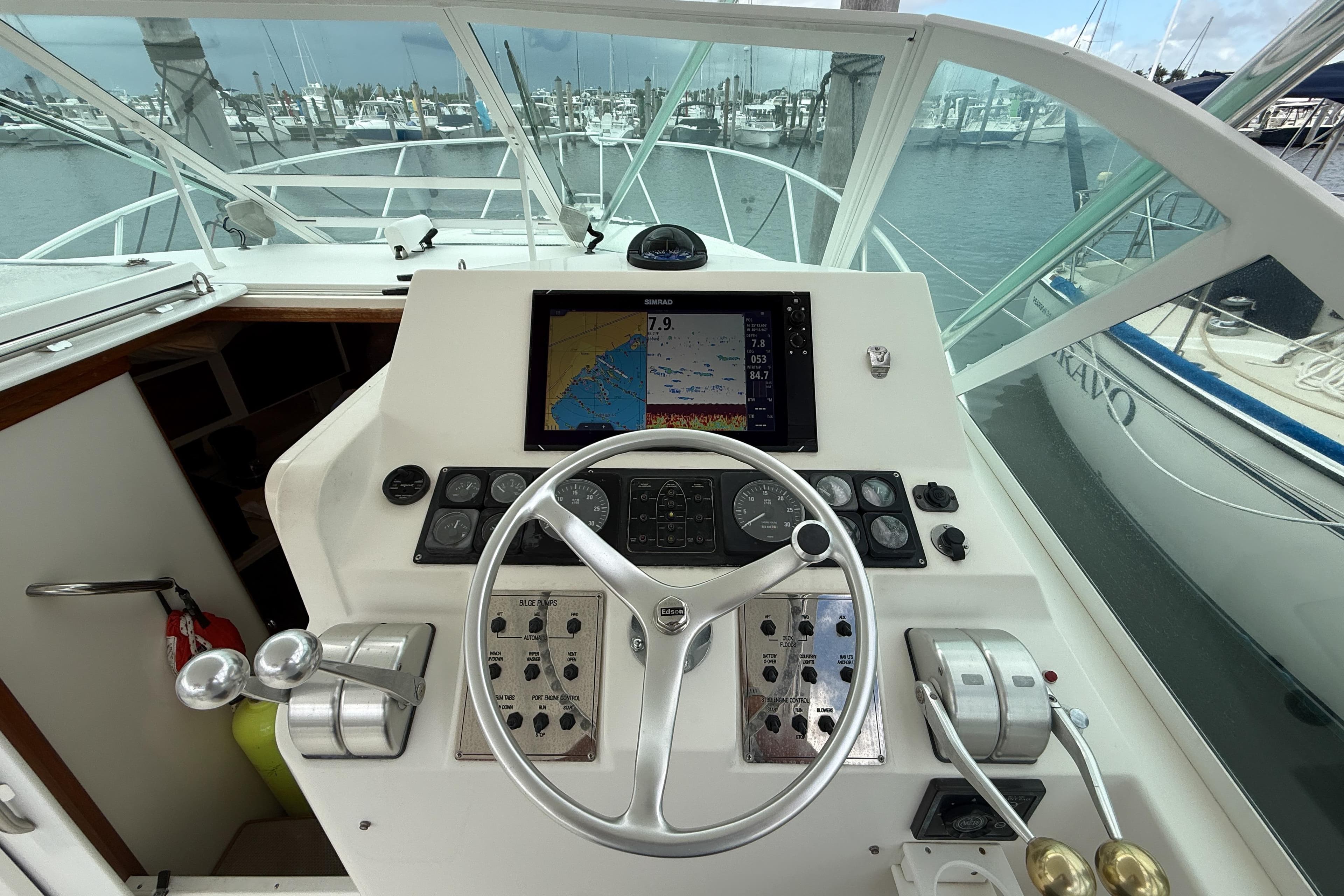1998 Cabo 31 Express boat helm with navigation controls and marina view.