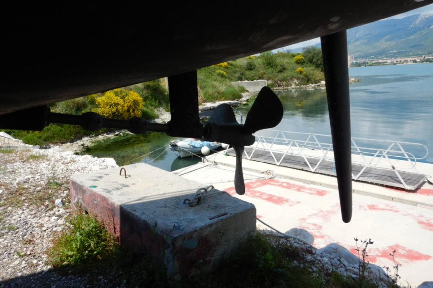 Underwater view of Lagoon 620 Esense 2018 yacht propeller near dock.