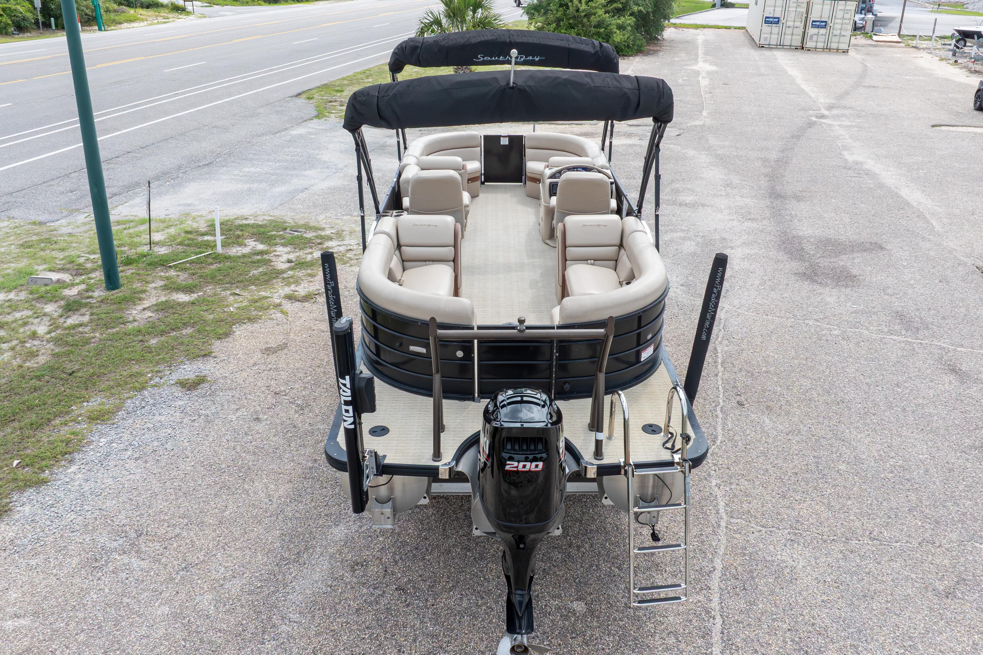 2018 South Bay 523RS pontoon boat with seating, black canopy, and outboard motor.